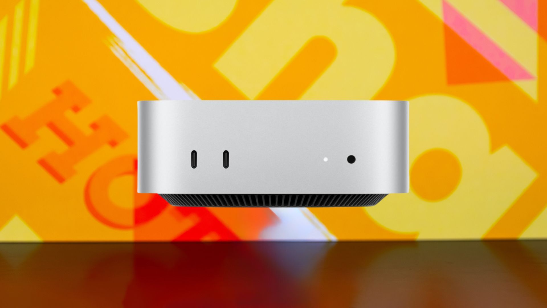 A Mac Mini 2024 appears on a bright abstract background.