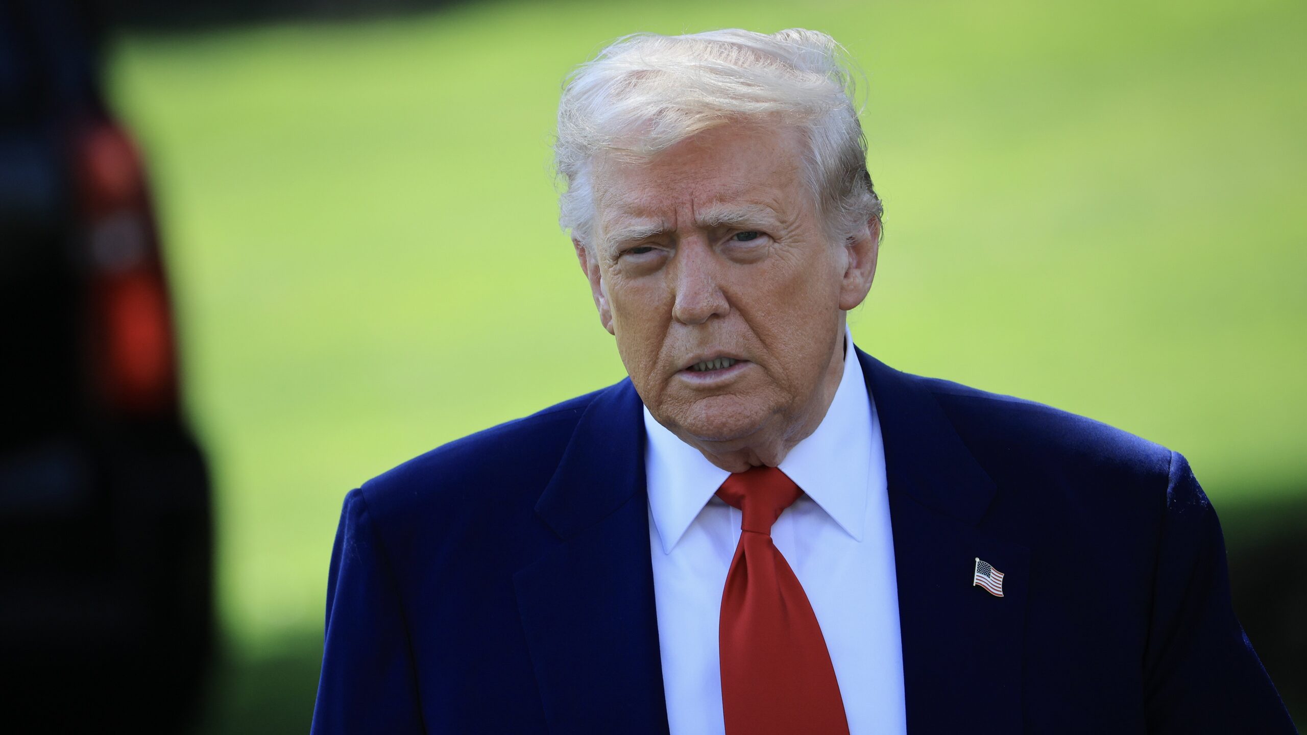 President Donald Trump on a green lawn.