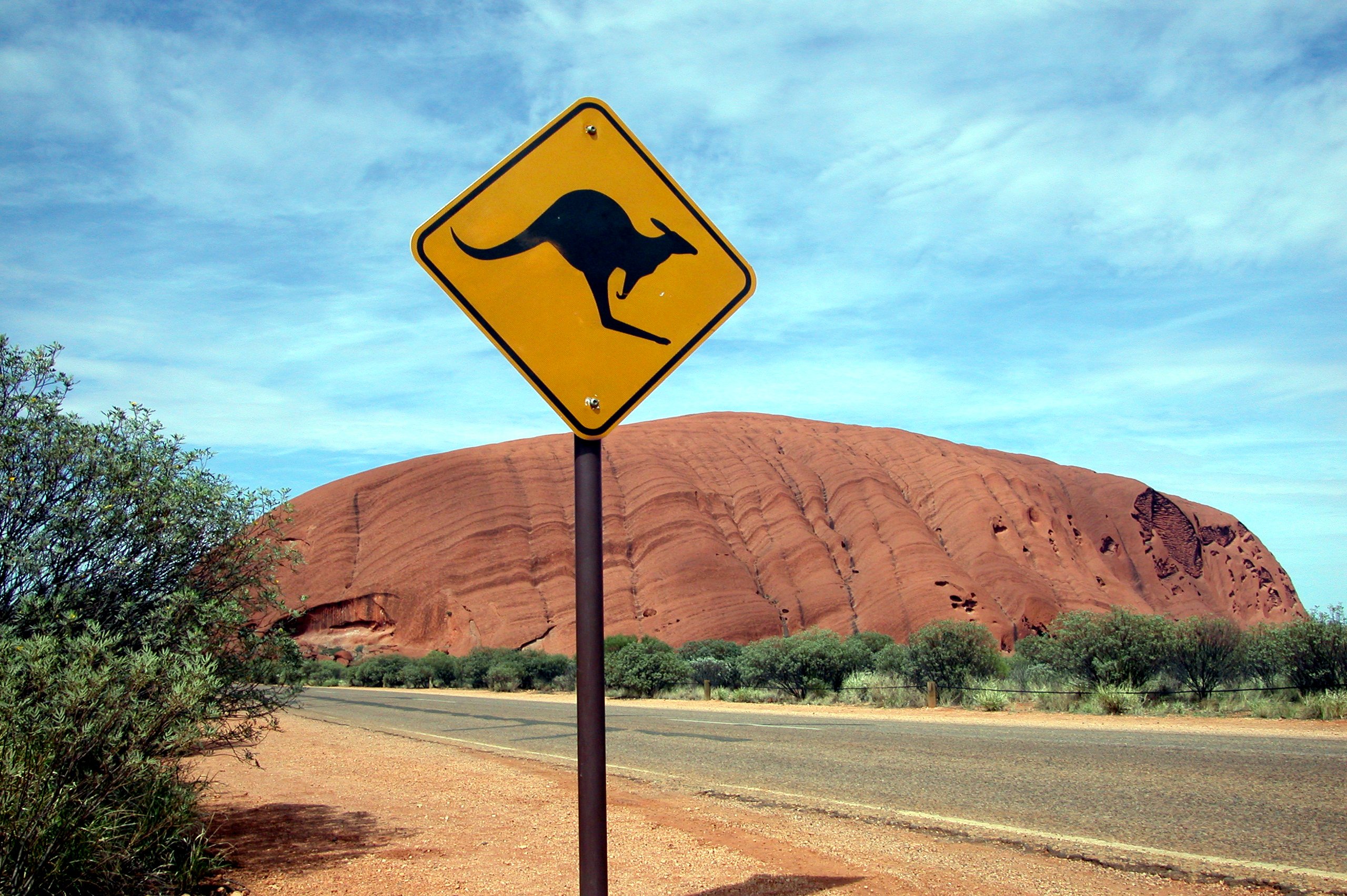 a kangaroo sign in front of a scenic desert scene