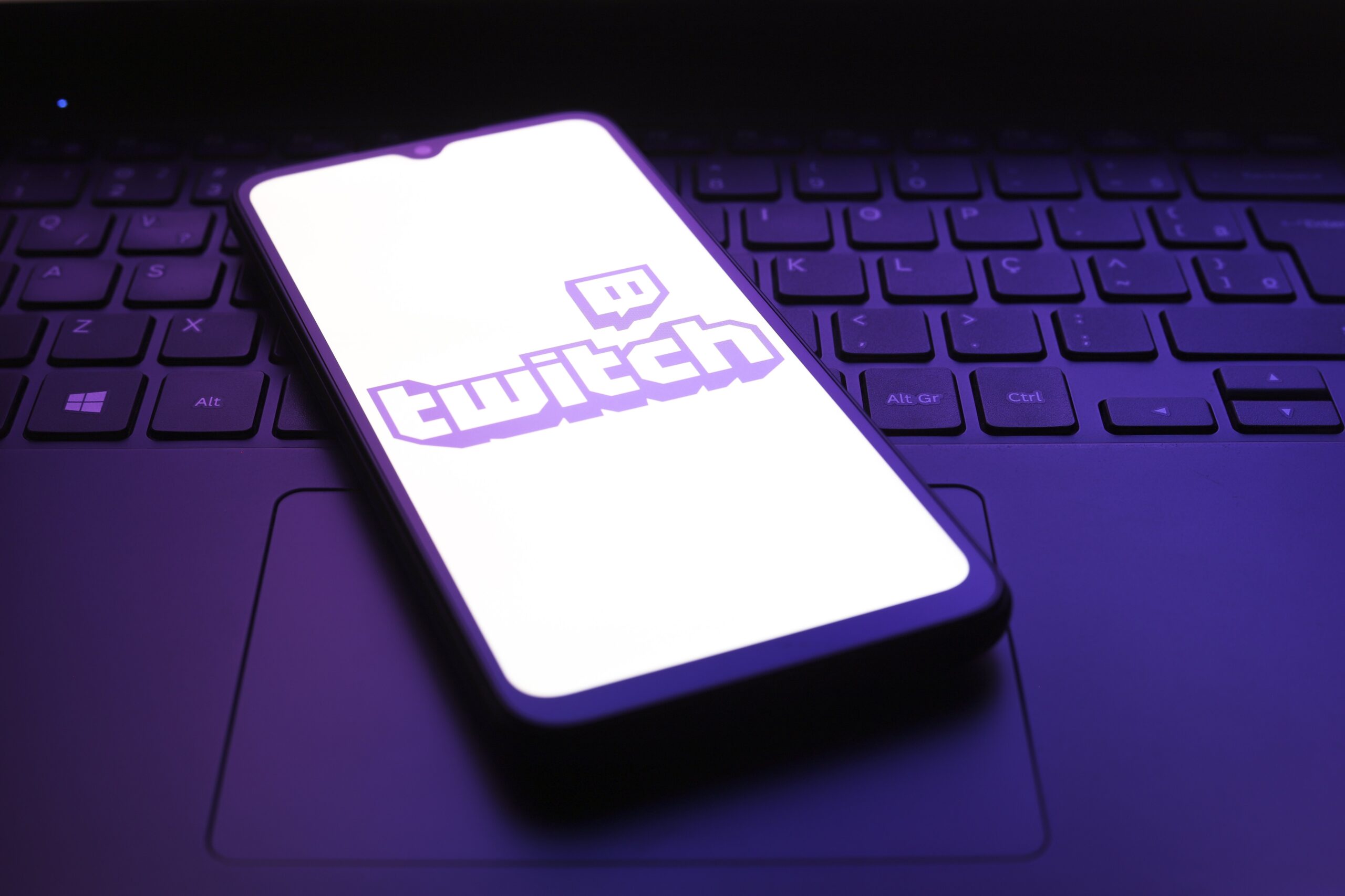 Twitch app logo appears on the screen of a smartphone