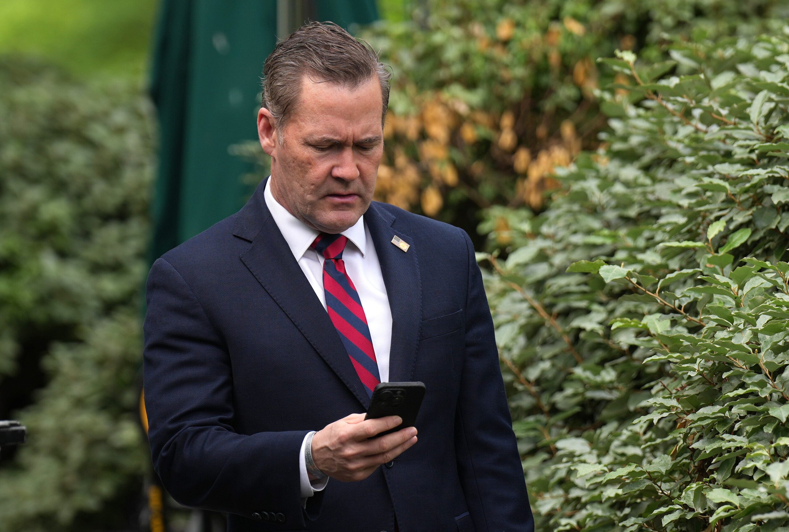 National Security Advisor Michael Waltz looks at his phone