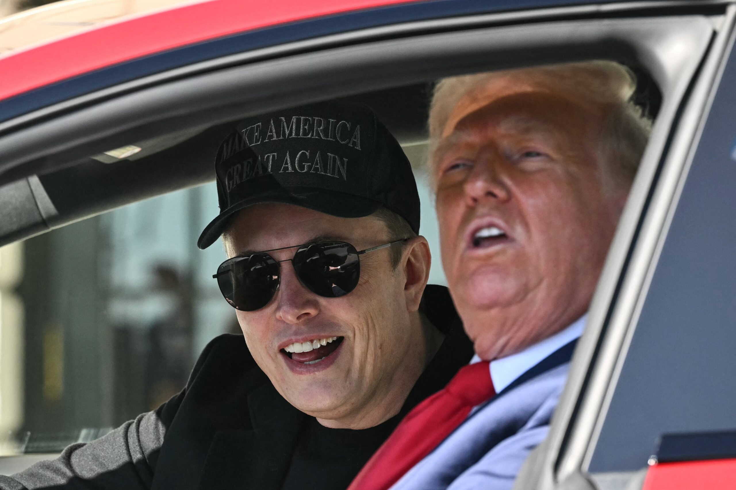 Elon Musk and Donald Trump sitting inside a Tesla outside the white house