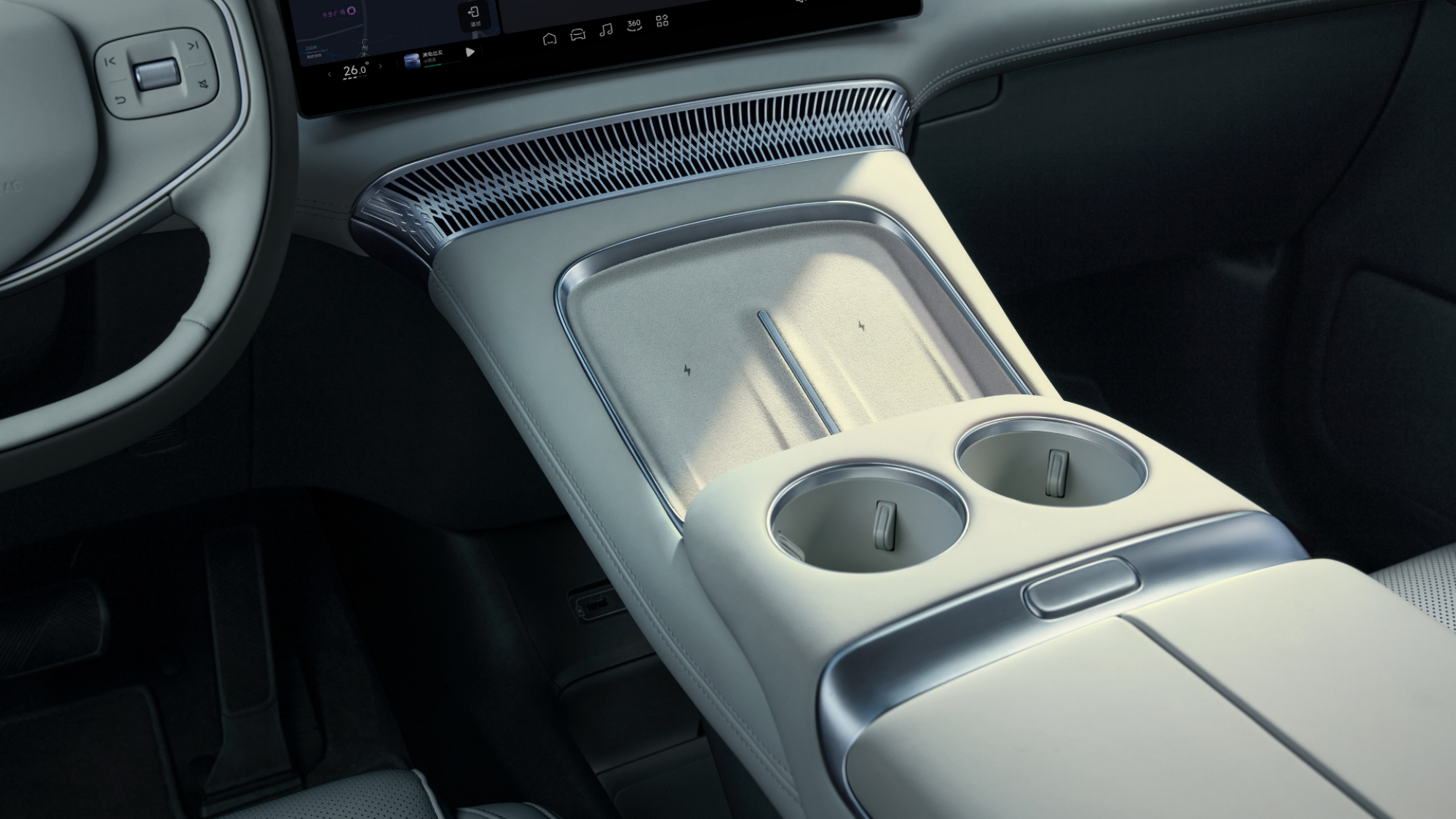 The XPENG X9's front seat cupholders and phone charging cradles.