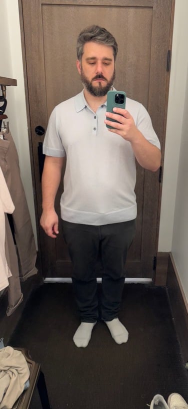author trying on a blue polo in dressing room