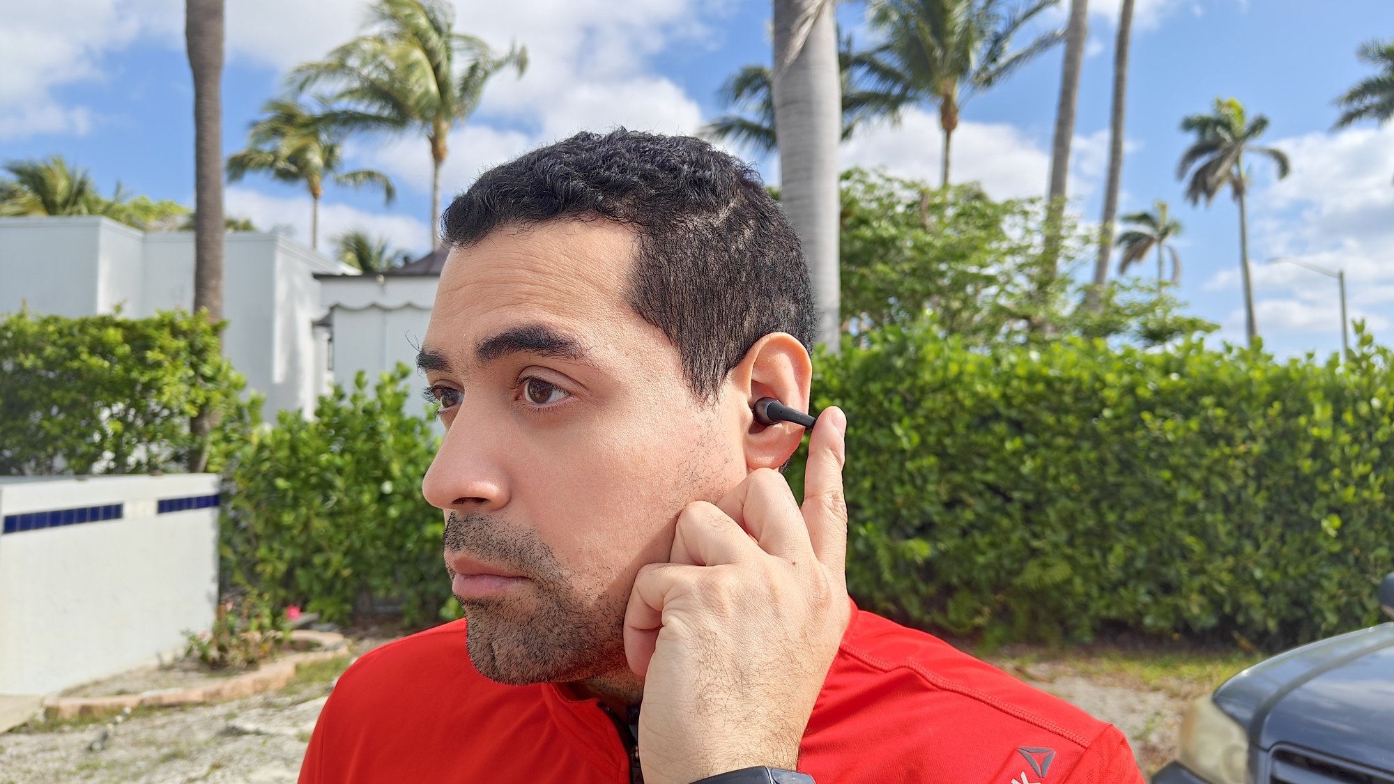 the author tapping touch controls on the shokz earbuds