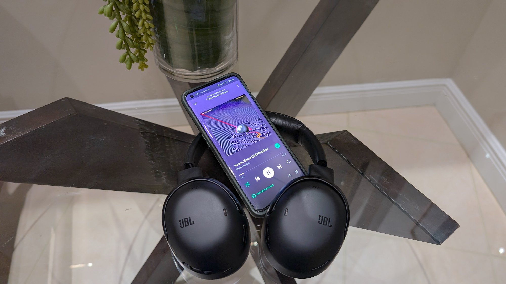 JBL headphones with phone open to spotify