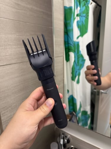 the panasonic multishape with beard trimming attachment in front of bathroom mirror