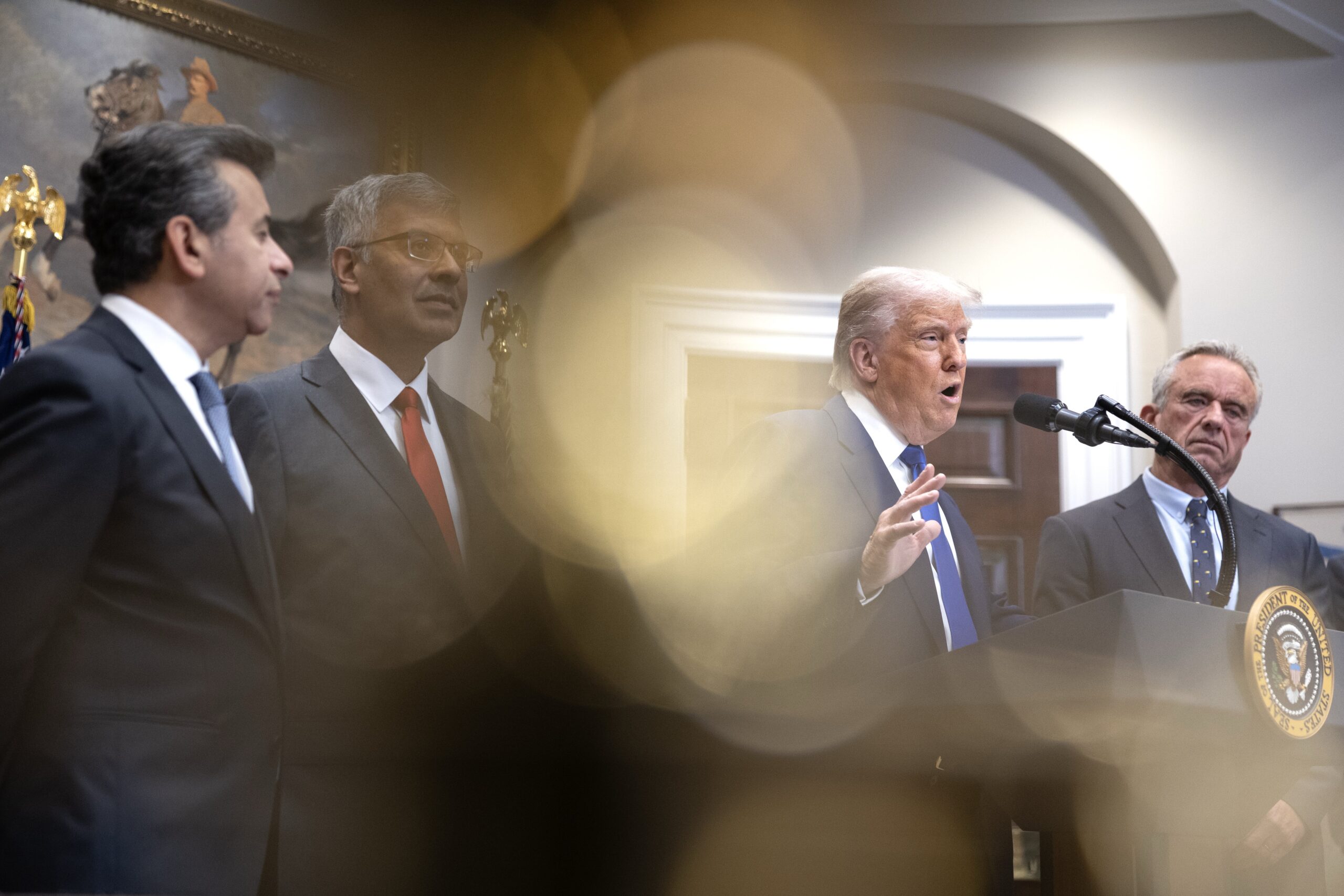 FDA Commissioner Martin Makary, National Institutes of Health Director Jay Bhattacharya, President Donald Trump and Health and Human Services Secretary Robert F. Kennedy Jr. stand at a podium.