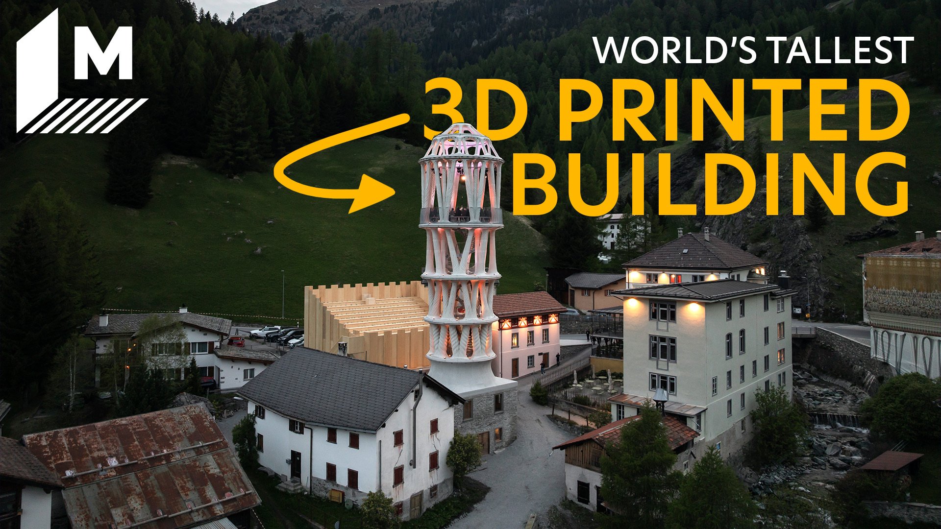 A drone shot captures the tall white Tor Alva at dusk, as lights have just gone out. It's surrounded by Mulegns' traditional houses, and the Alps are seen in the background