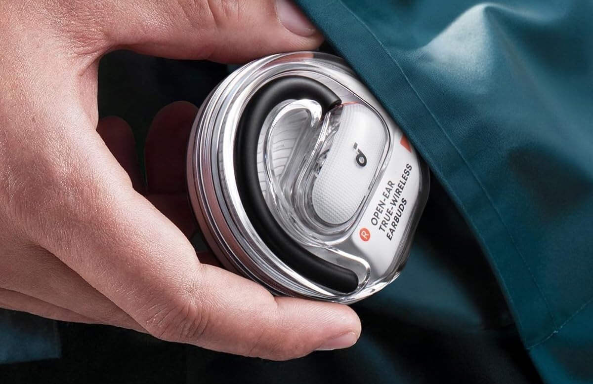 a person's right hand takes the soundcore v40i open-ear headphones case out from a pocket