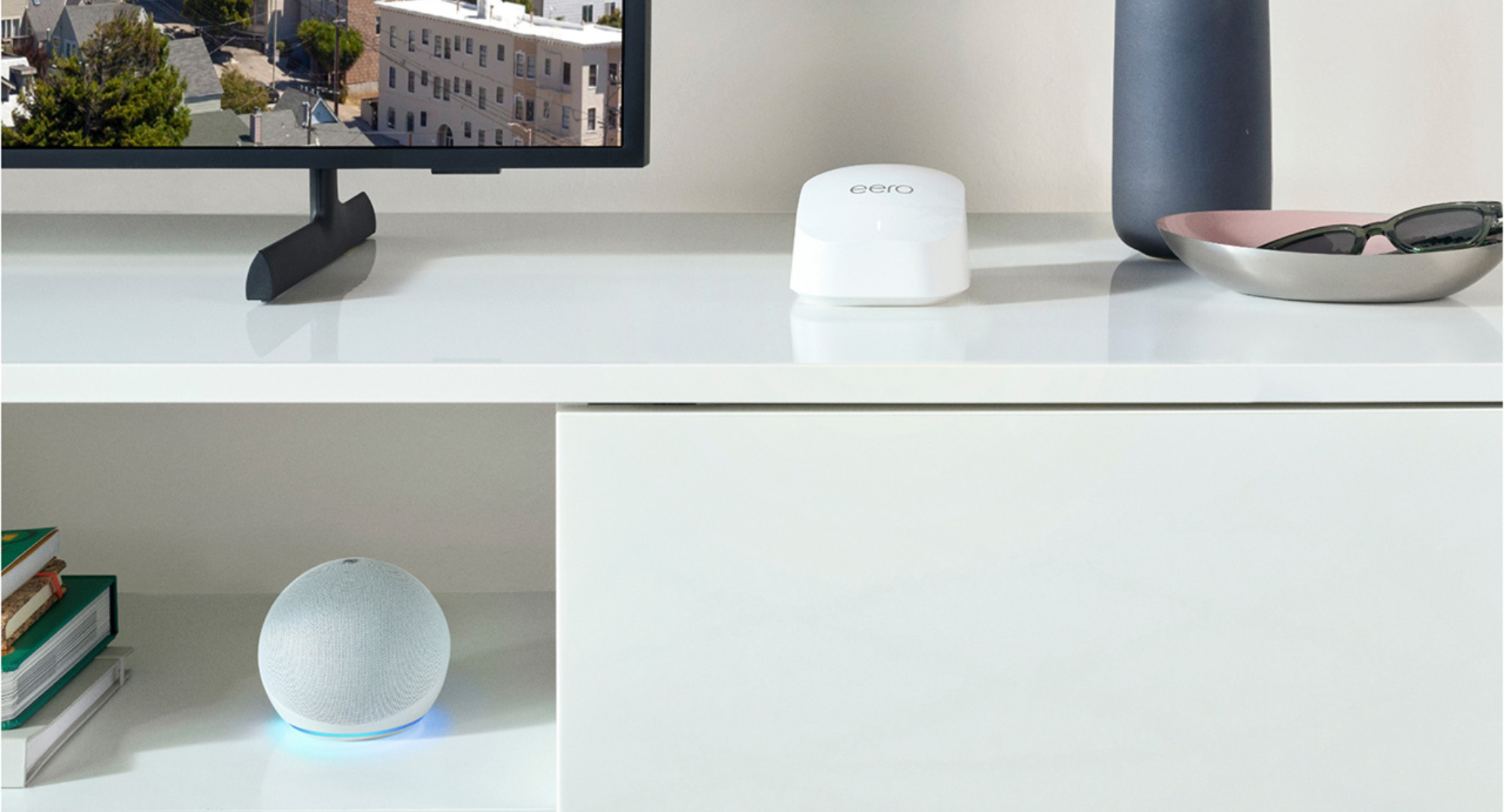 Amazon eero 6+ mesh WiFi router on a white media console next to a TV.