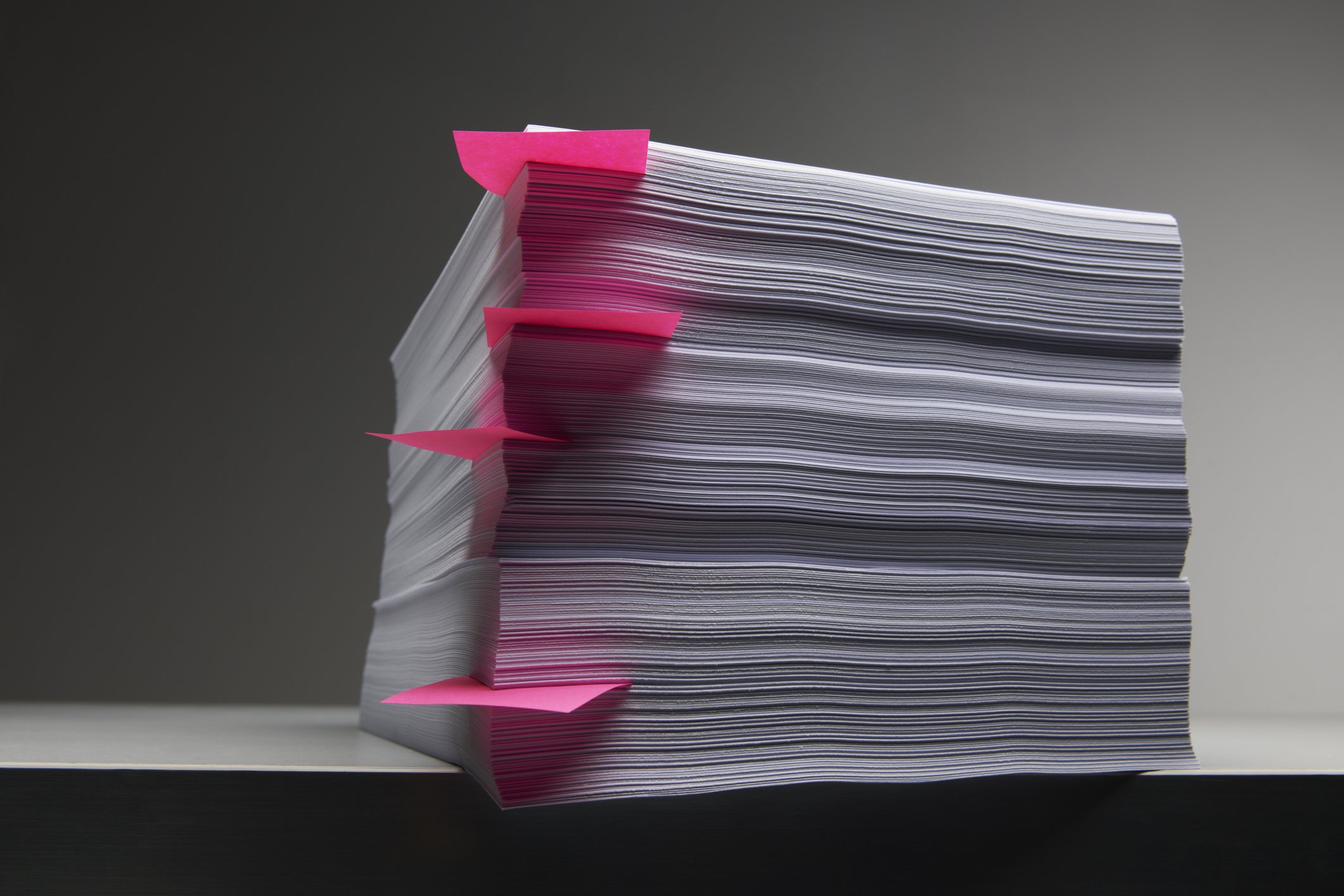 A large stacks of papers with post-it notes in between some of the pages.