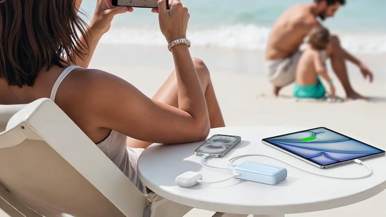 woman using Anker Zolo power bank to charge devices on beach