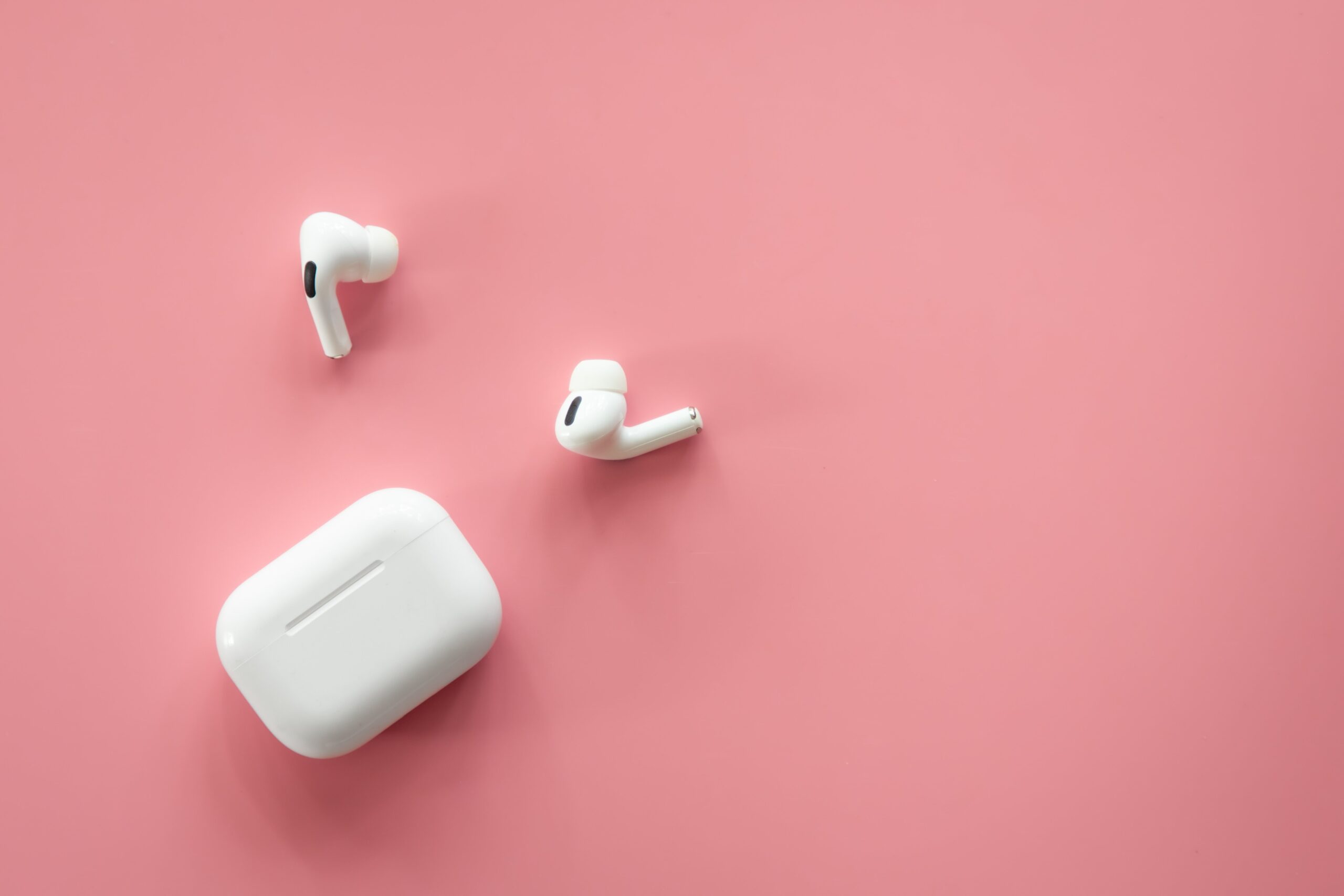white wireless headphones on a pink background