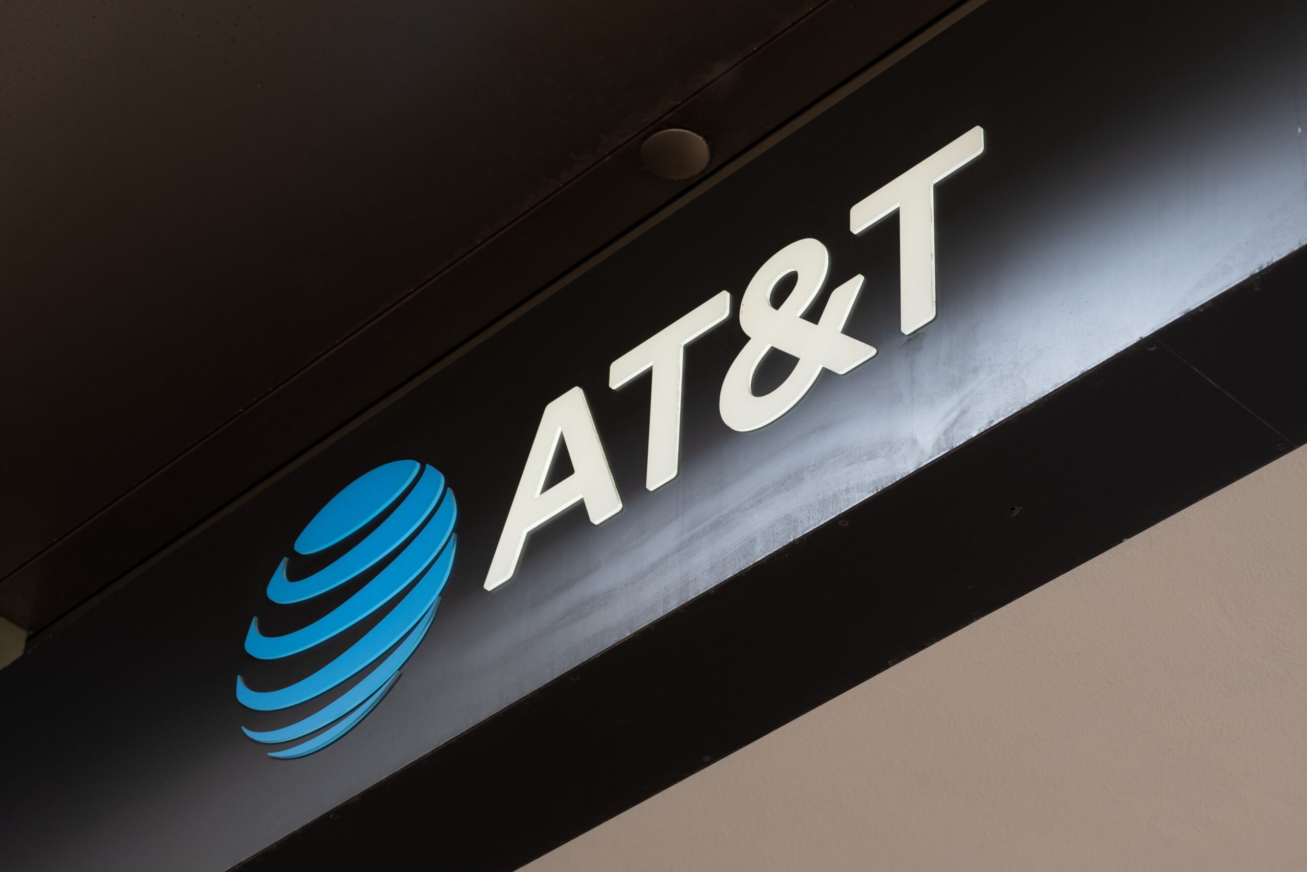 Illuminated AT&T logo sign on dark storefront awning, San Francisco, California, May 13, 2025.