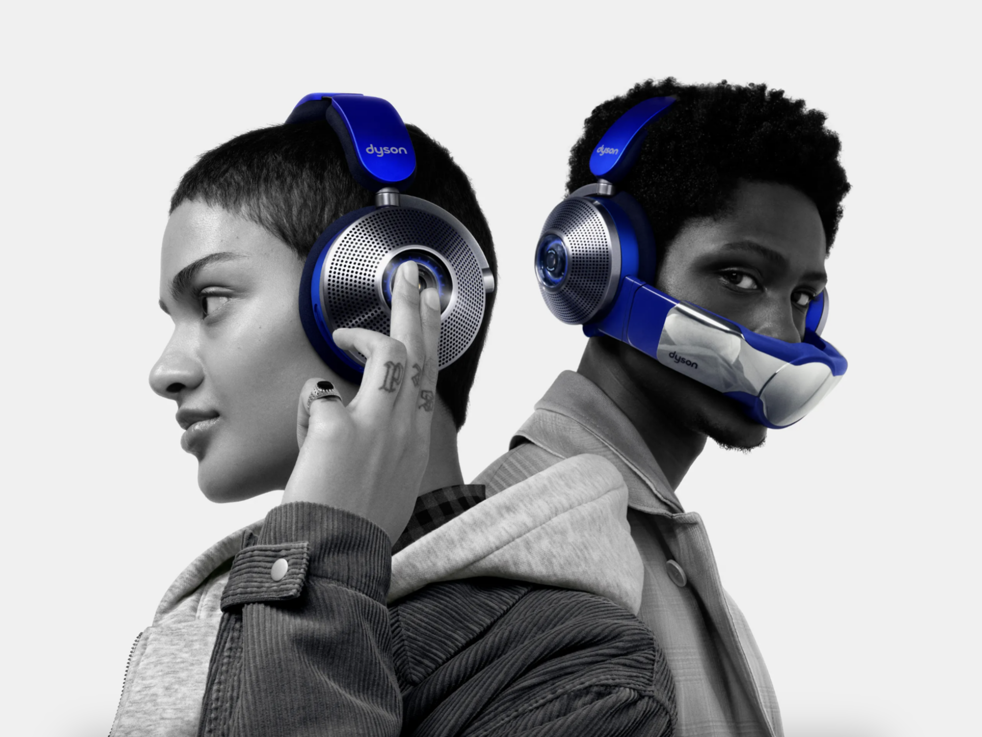 Two people wearing Dyson Zone headphones, one with air purifying mask on and one without