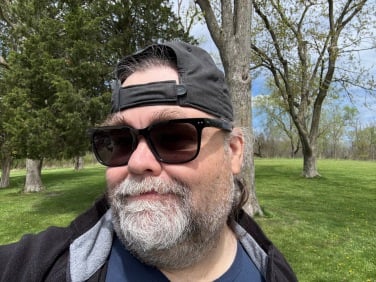 the author wearing nuance hearing glasses in a park