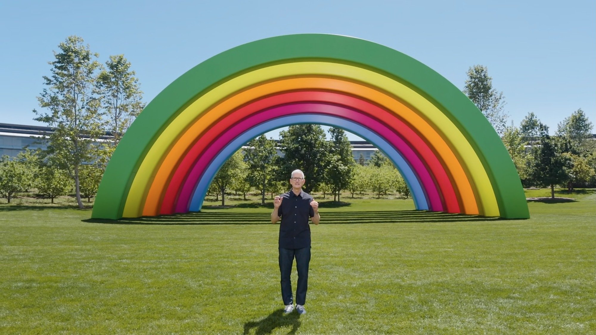 apple ceo tim cook at apple park in front of rainbow sculpture