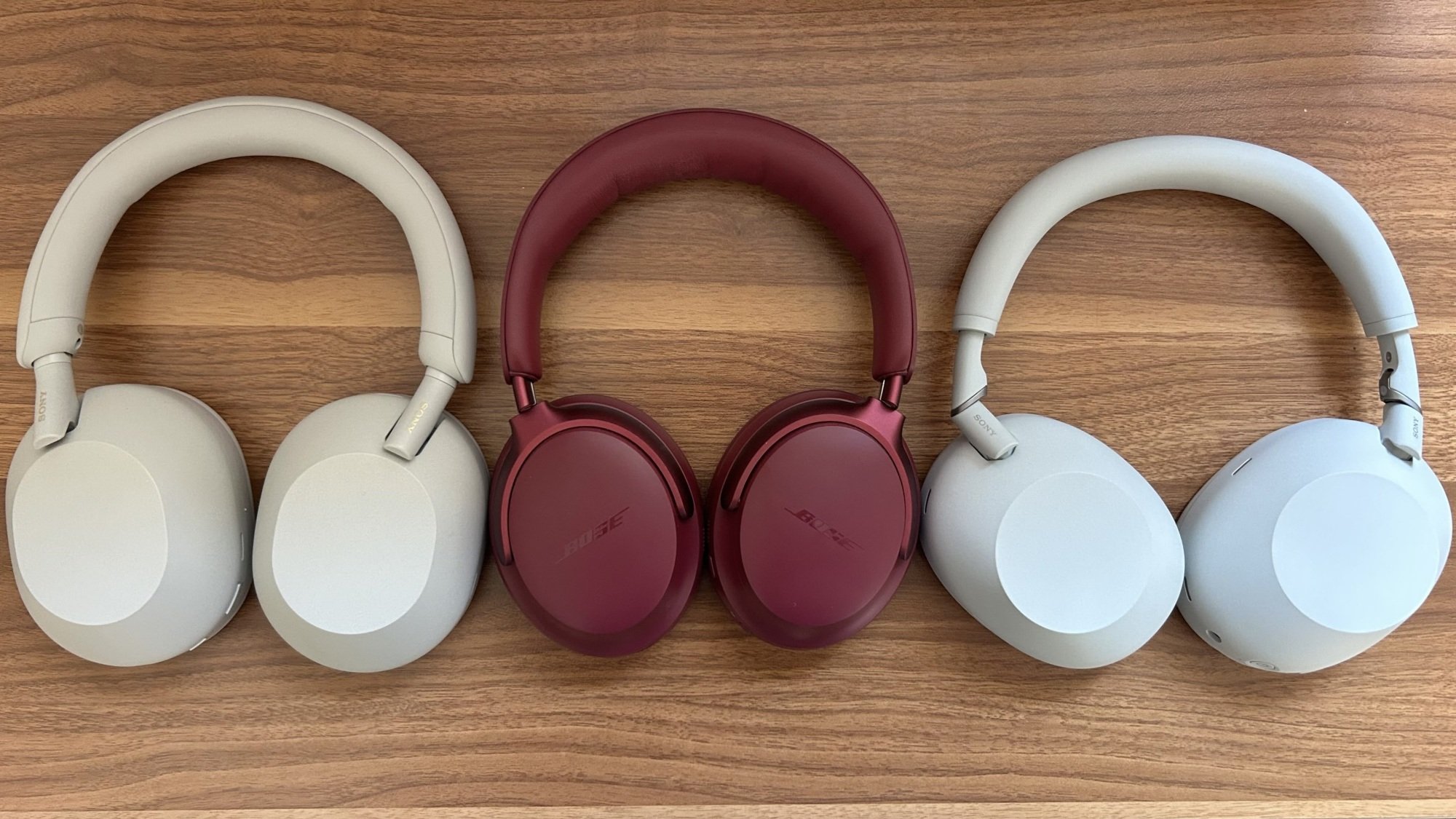 sony wh-1000xm5, bose quietcomfort ultra, and sony wh-1000xm6 headphones lined up on a desk