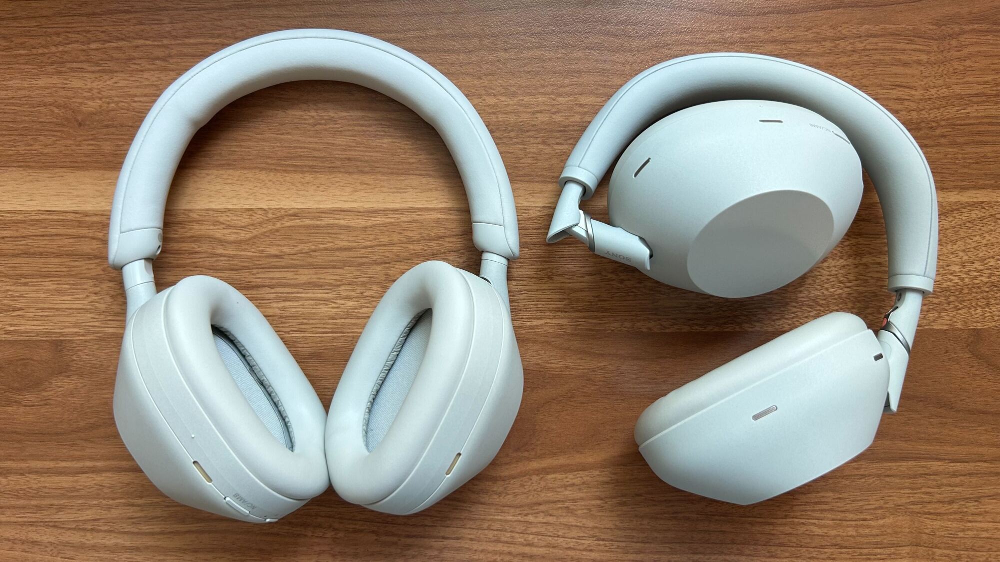 sony wh-1000xm5s on the left on desktop next to folded up sony wh-1000xm6s