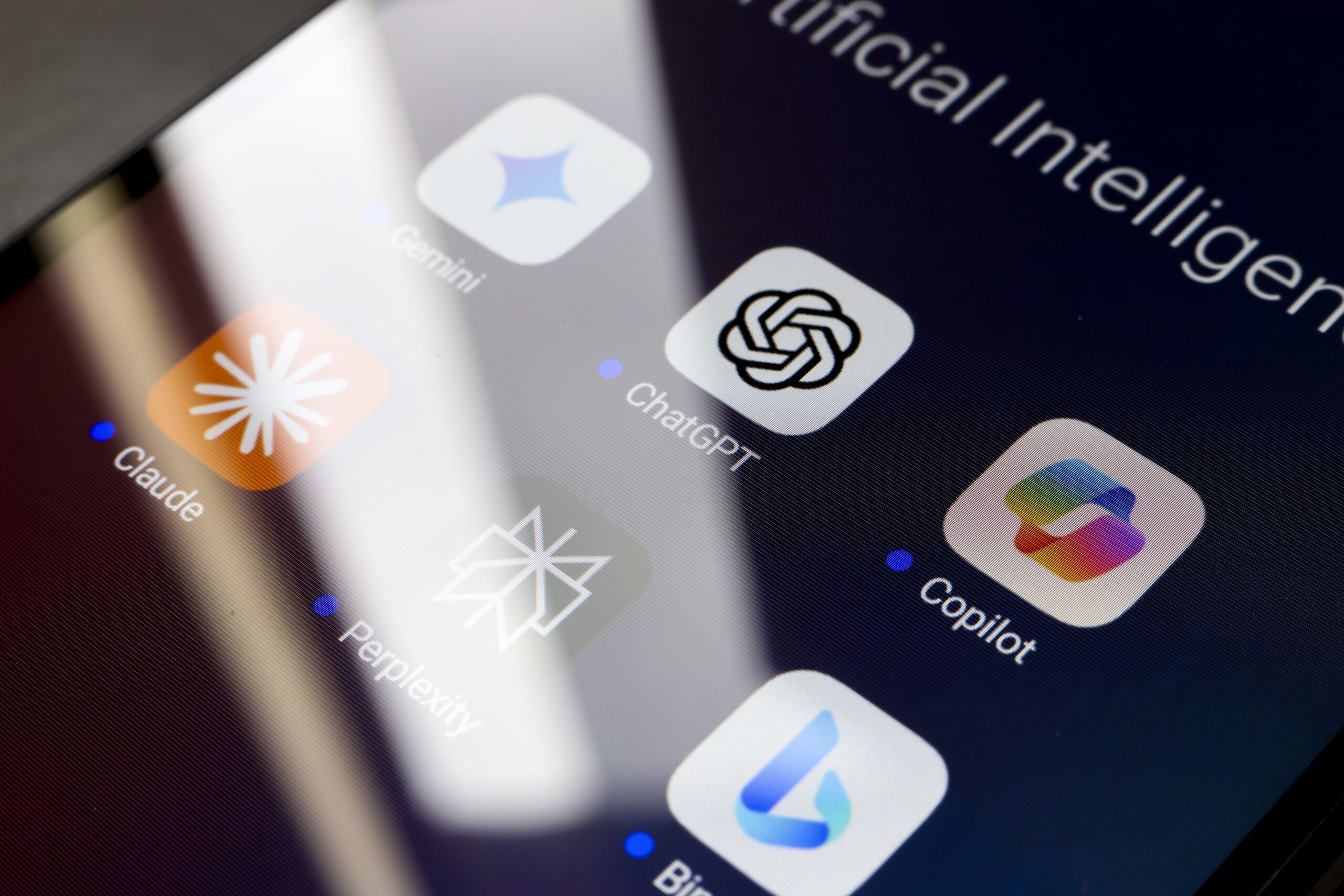 A phone screen showing a folder of AI chatbot apps, including Claude, Gemini, ChatGPT, CoPilot, and DeepSeek.
