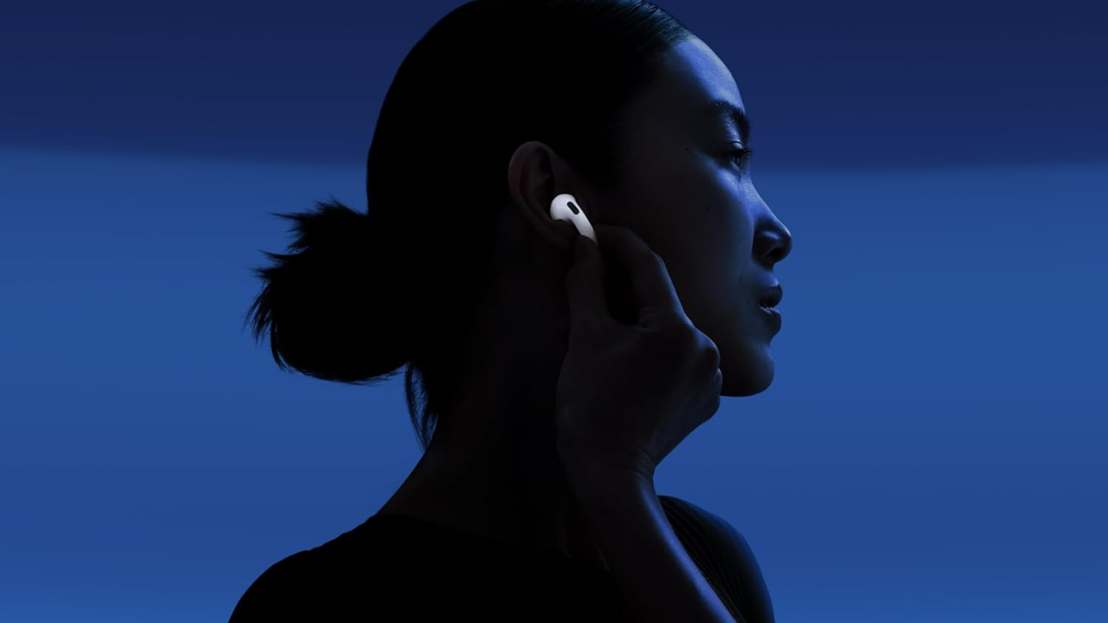 woman wearing AirPods 4 with blue shadowy background