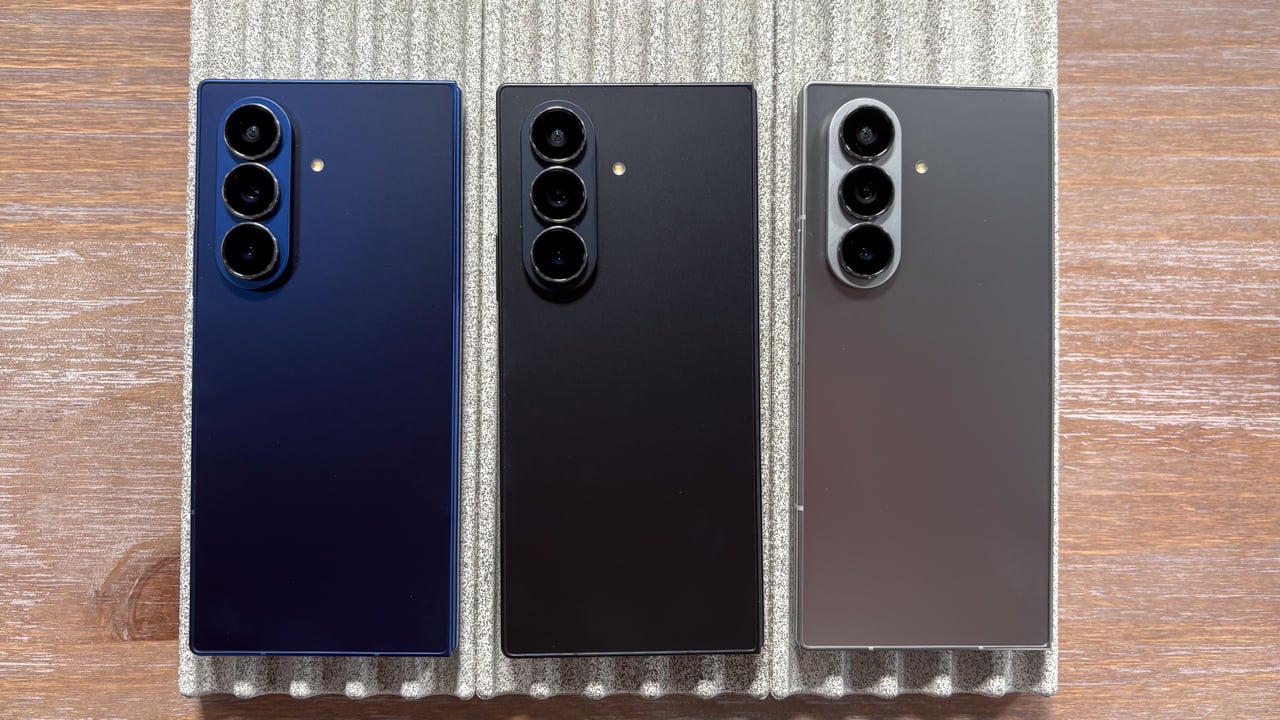 Three Samsung phones in a row on a table.