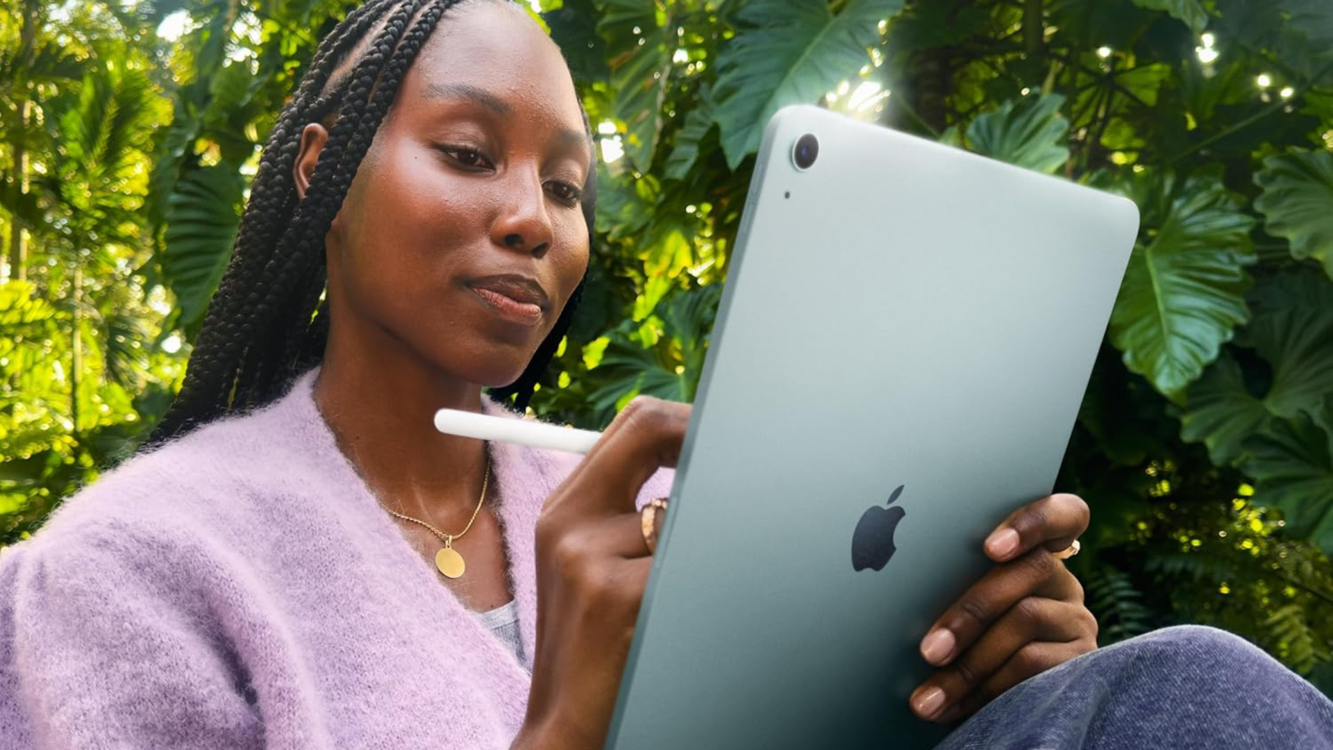 A person holding an Apple iPad with an Apple pencil