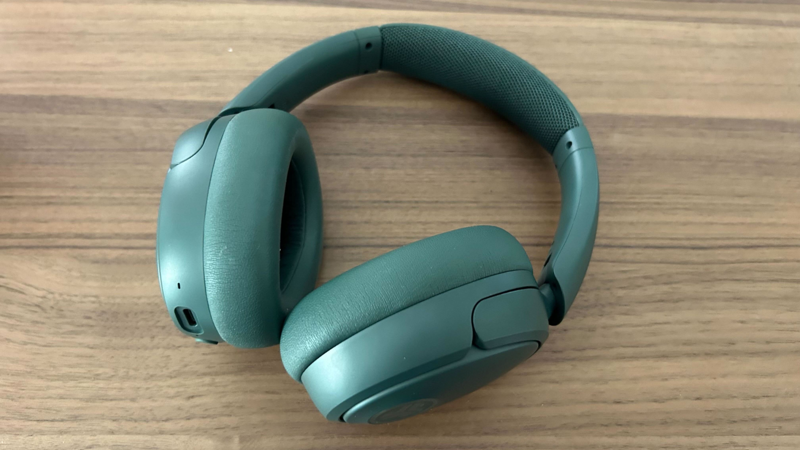 the sage jlab jbuds lux anc headphones on a wooden surface