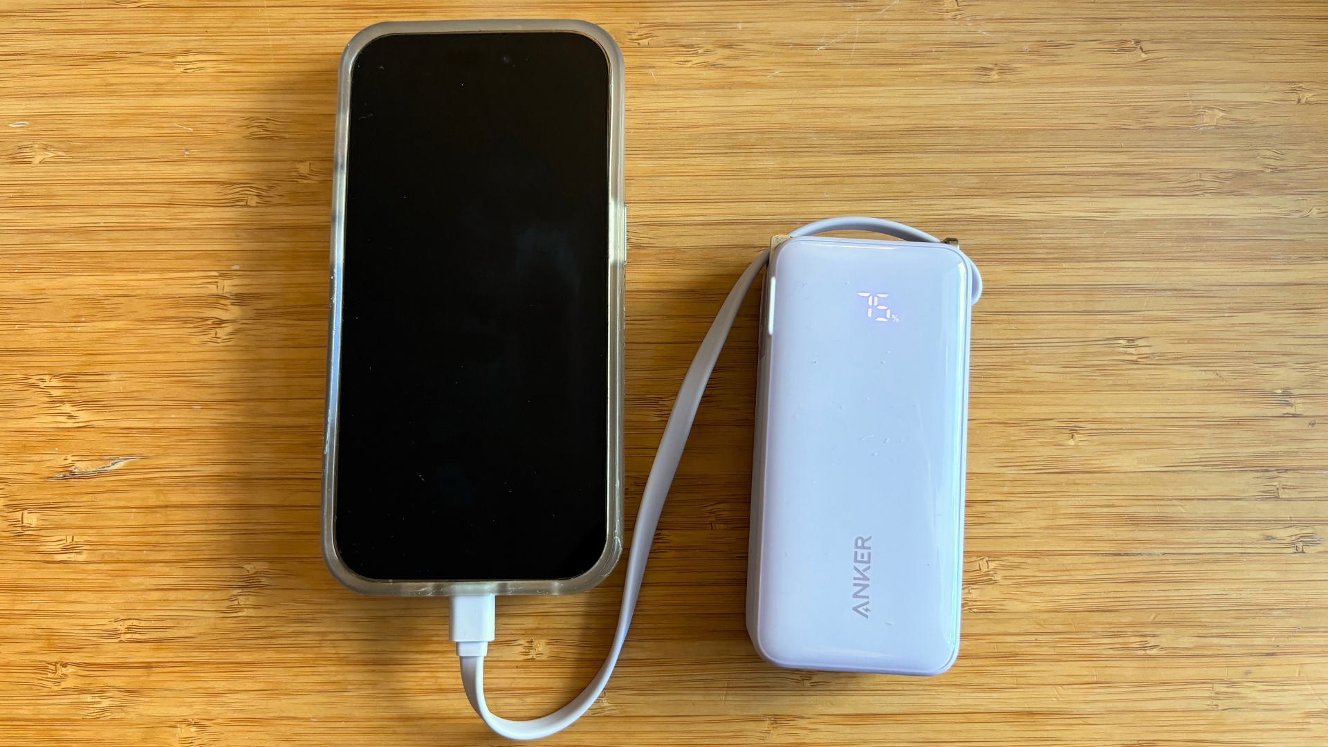 An iPhone 14 Pro plugged into the Anker Nano 3-in-1 power bank
