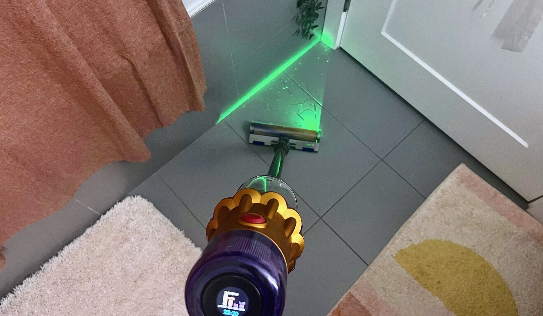Dyson V12 Detect Slim cleaning bathroom floor with green laser