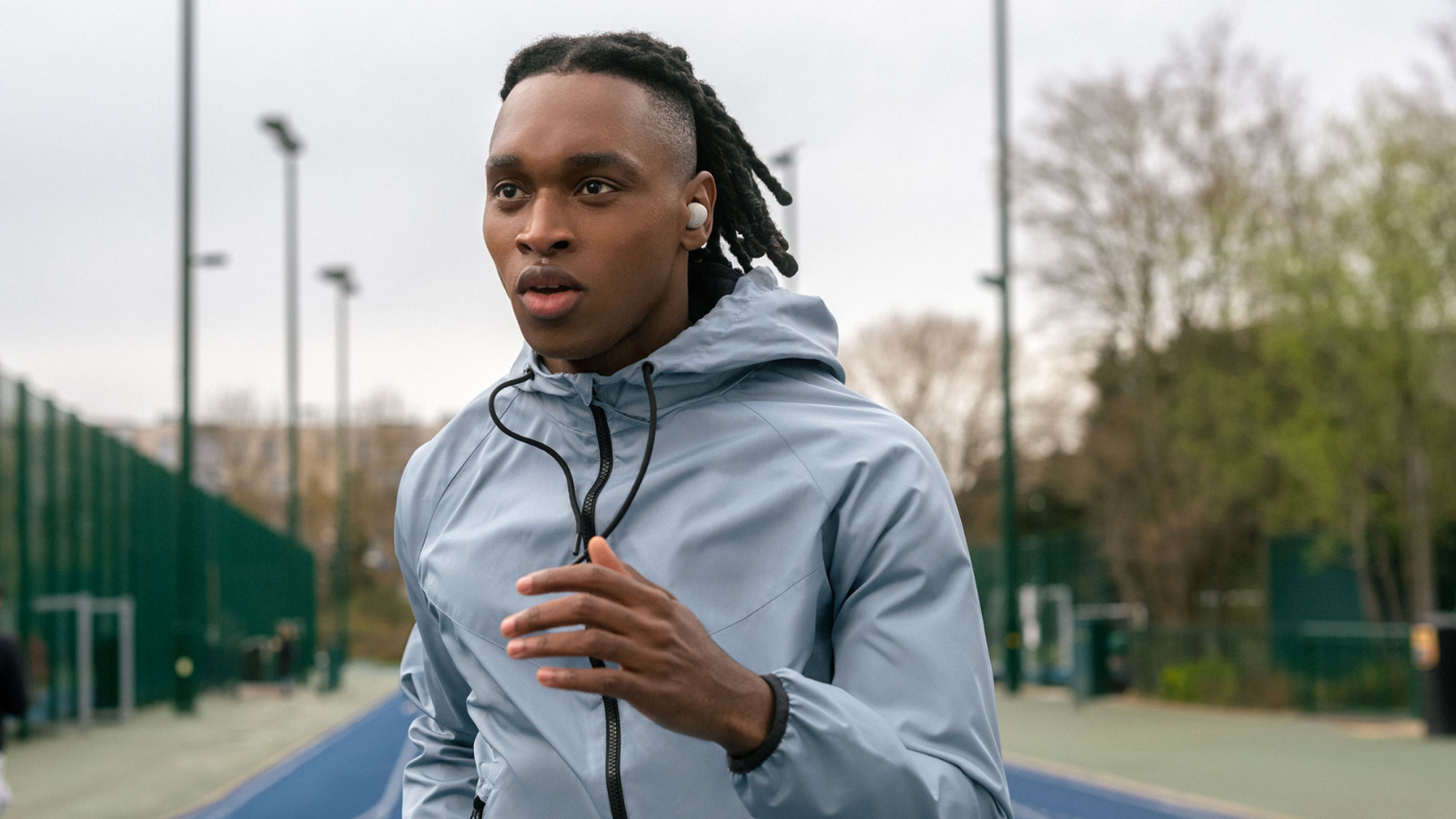 man running with Sony WH-1000XM5 earbuds in
