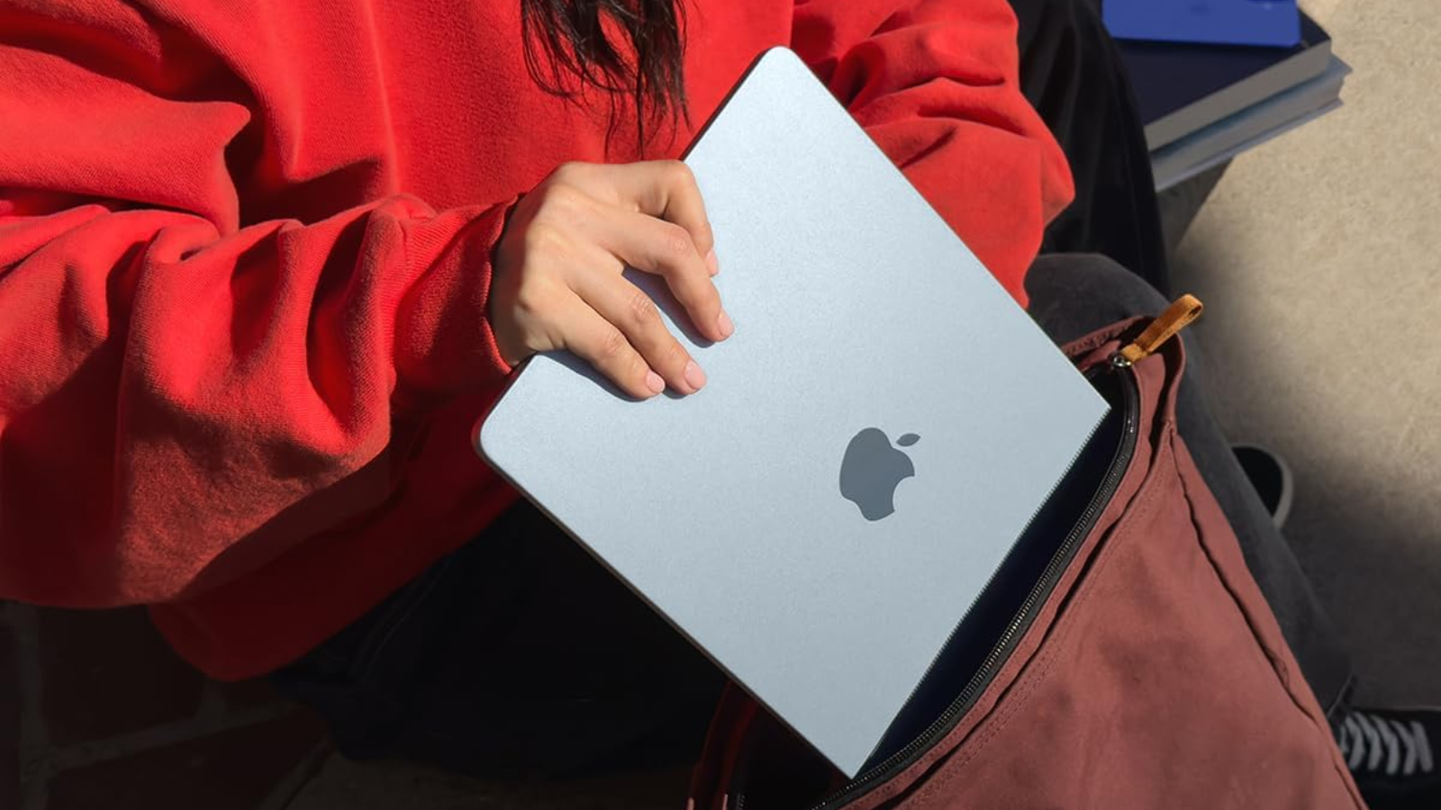  girl placing a 13-inch m4 apple macbook air into a backpack
