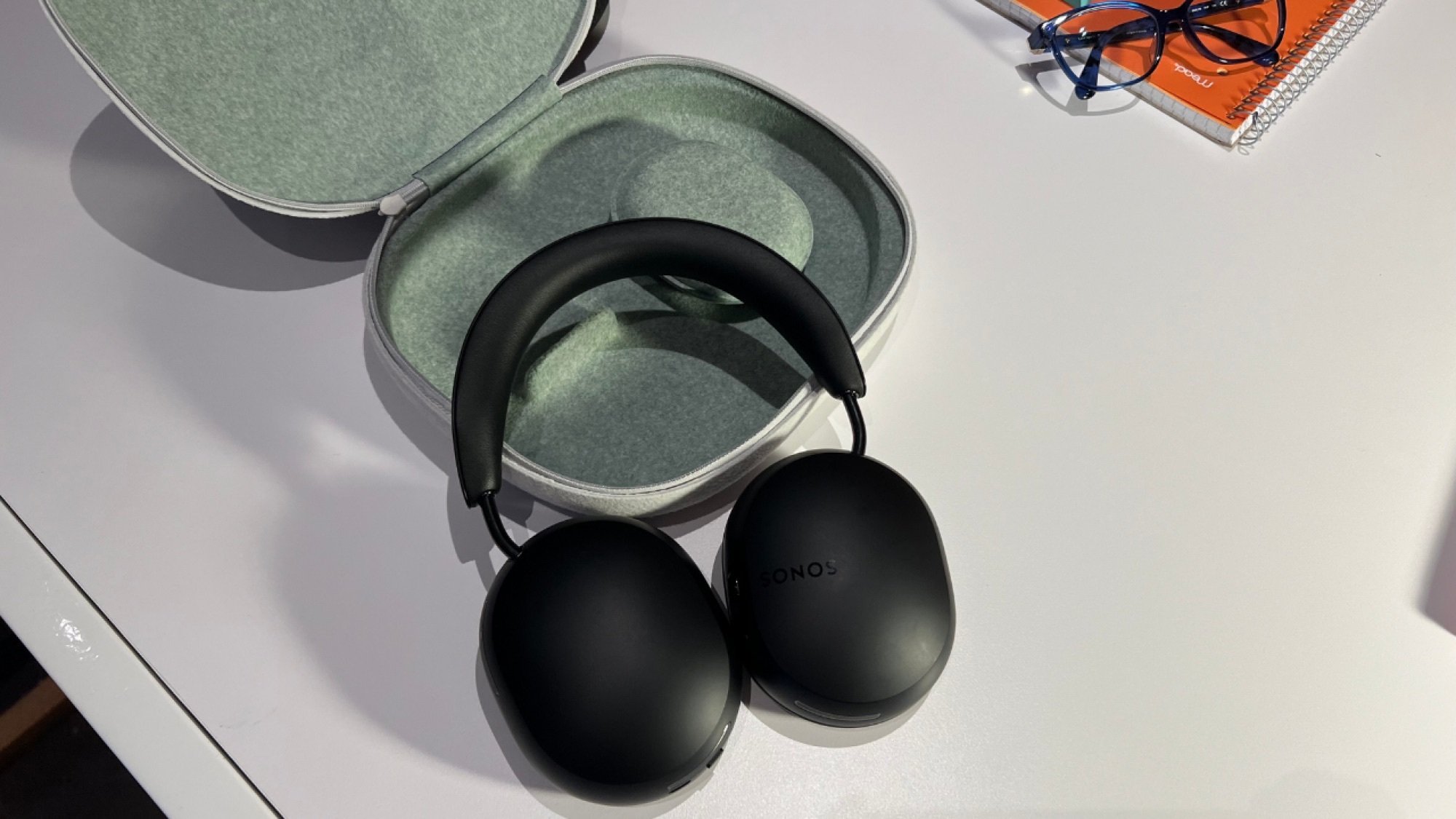 the Sonos Ace headphones laying on a table with their case