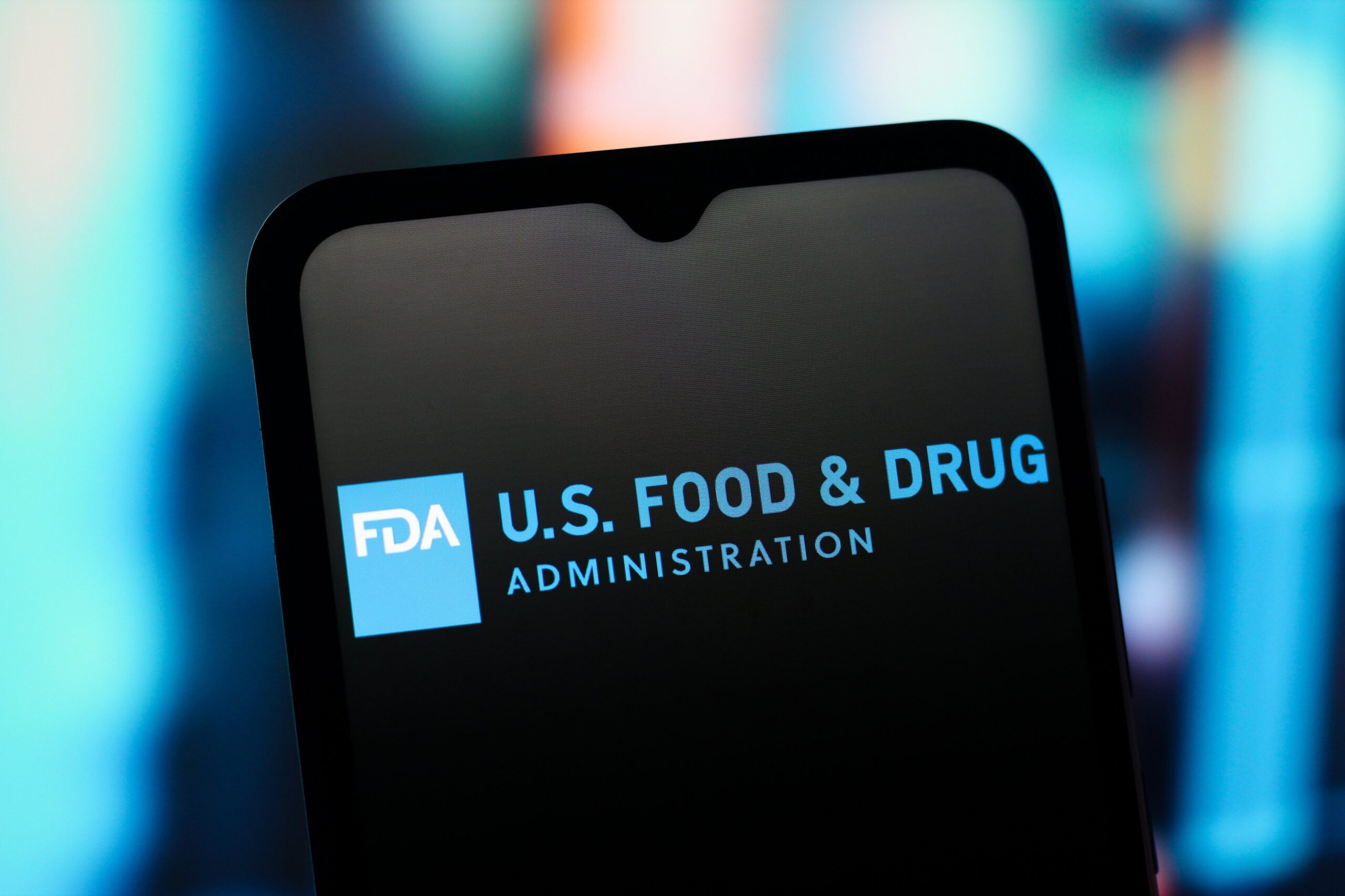 A phone displays the US FDA logo on a black background.