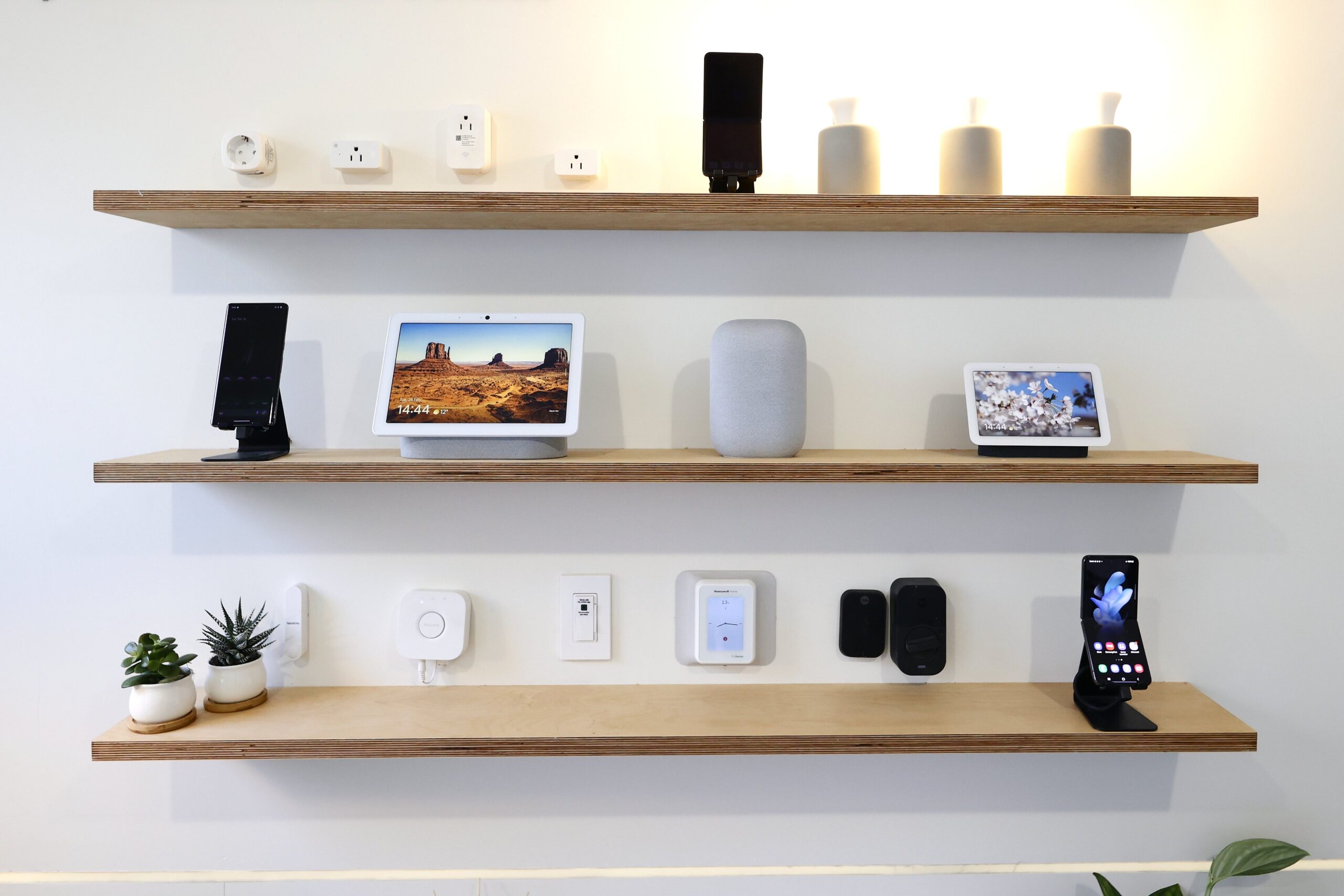 Several Google and Nest devices, including the Nest Audio speaker, Nest Hub 2nd Generation and Nest Hub Max displays, the GE Cync Wifi Soft White Smart Bulb, and the Philips Hue A19 Smart Bulb smart lightbulbs, The Philips Hue Smart Plug and the C by GE Smart Plug, exhibited on the Android Smart Home display