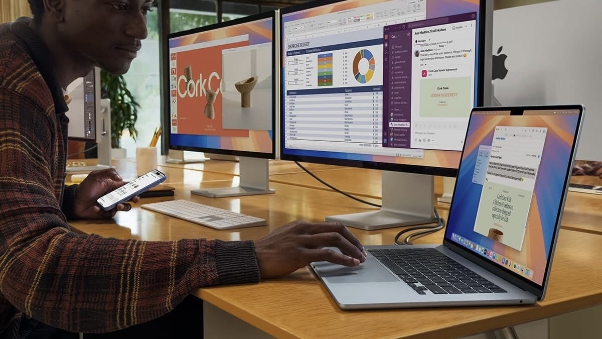 person working at desk on 15-inch macbook air connected to two external displays