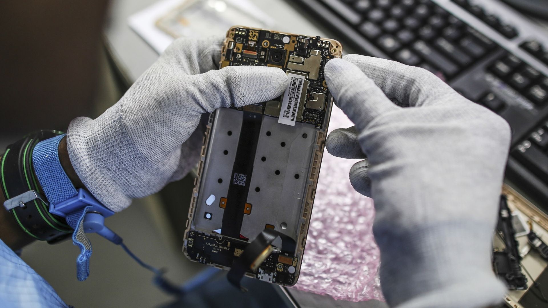 A technician repairs a smartphone at a Xiaomi corp. service center.