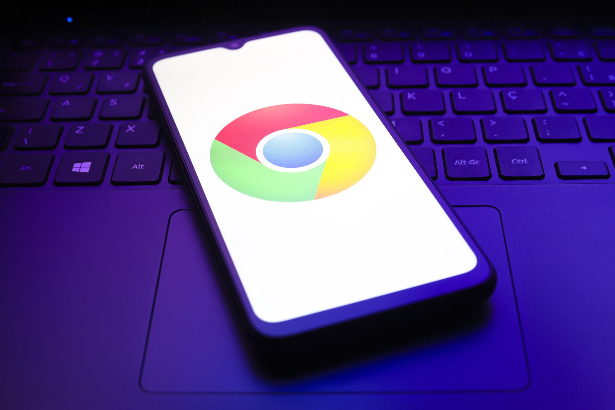 google chromo logo on phone, which is rested on a laptop