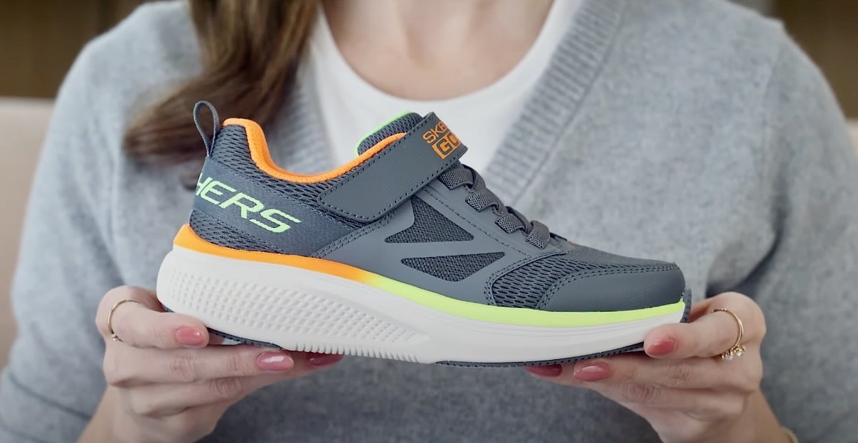 woman holding skechers sneaker with airtag holder
