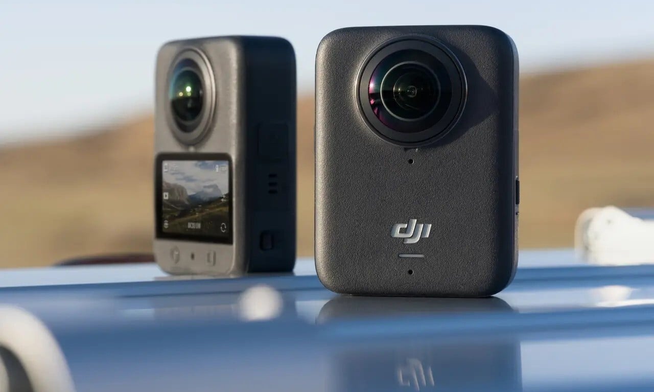 The DJI Osmo 360 camera sits on top of a car hood in the sun