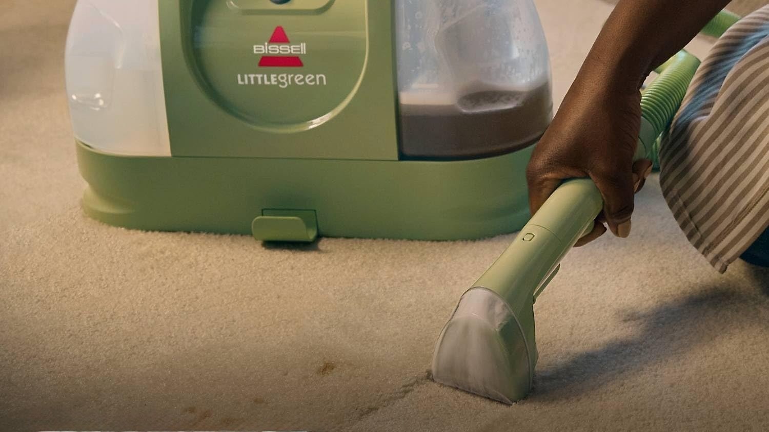 woman using bissell little green carpet cleaner