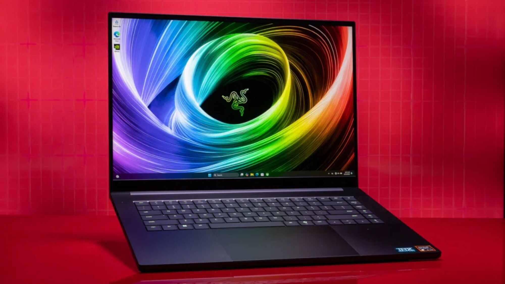 razer blade 16 laptop with colorful abstract screensaver against a red backdrop