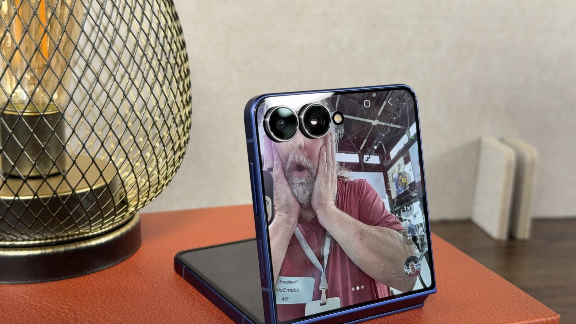 A person depicted on a phone screen pretending the cameras on the screen are his eyes.