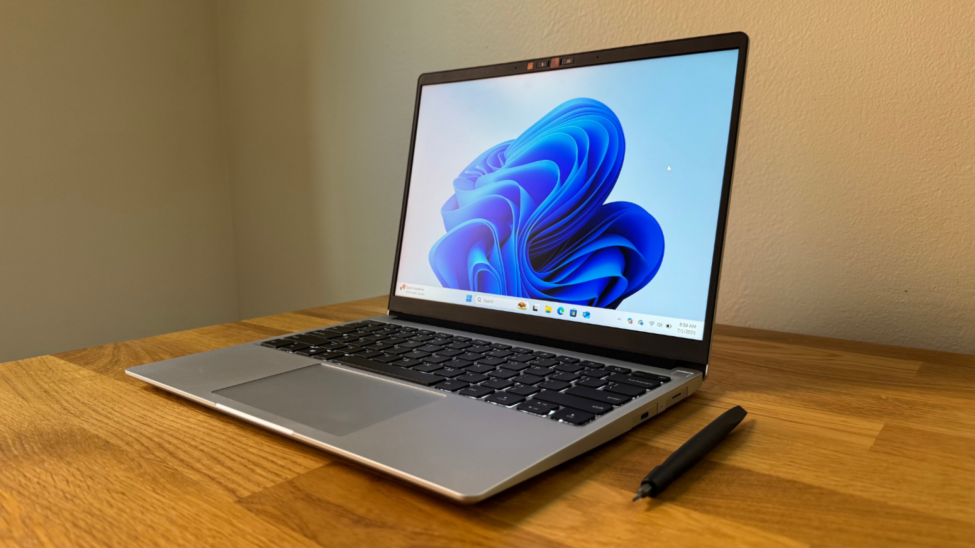 the framework laptop 13 on a wooden desk next to a framework screwdriver