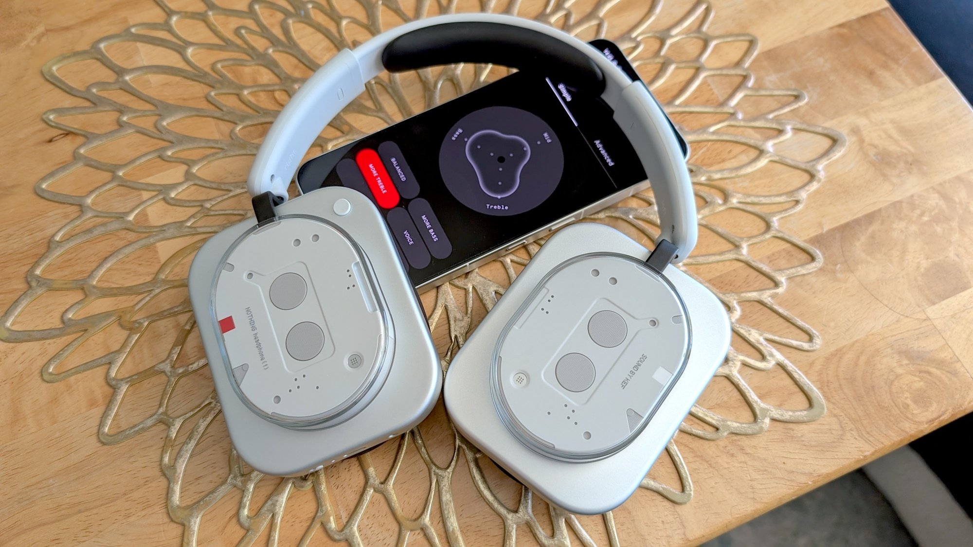 nothing headphones on top of phone with EQ app settings on screen