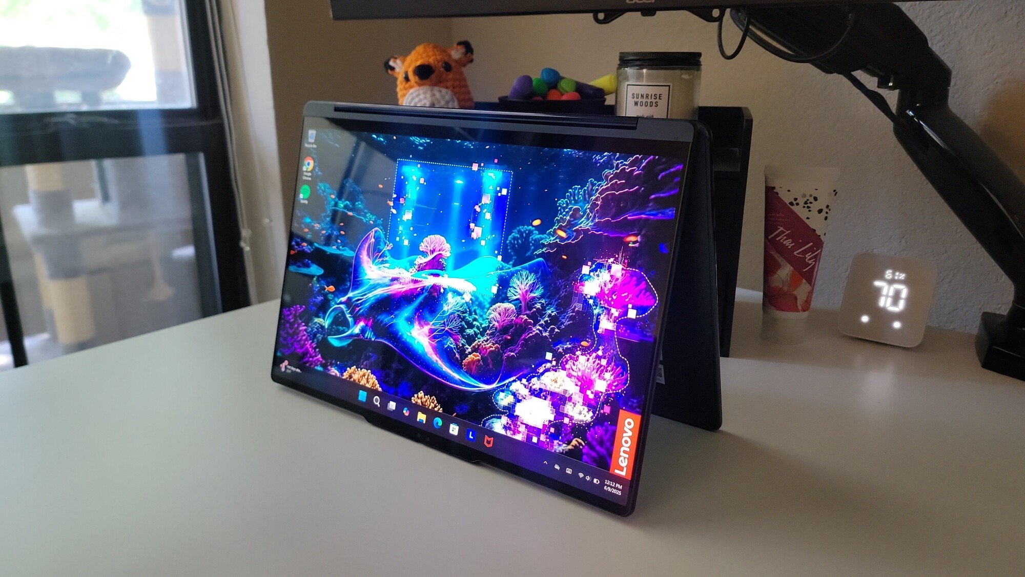 the lenovo yoga 9i 2-in-1 aura edition in tent mode on a desk