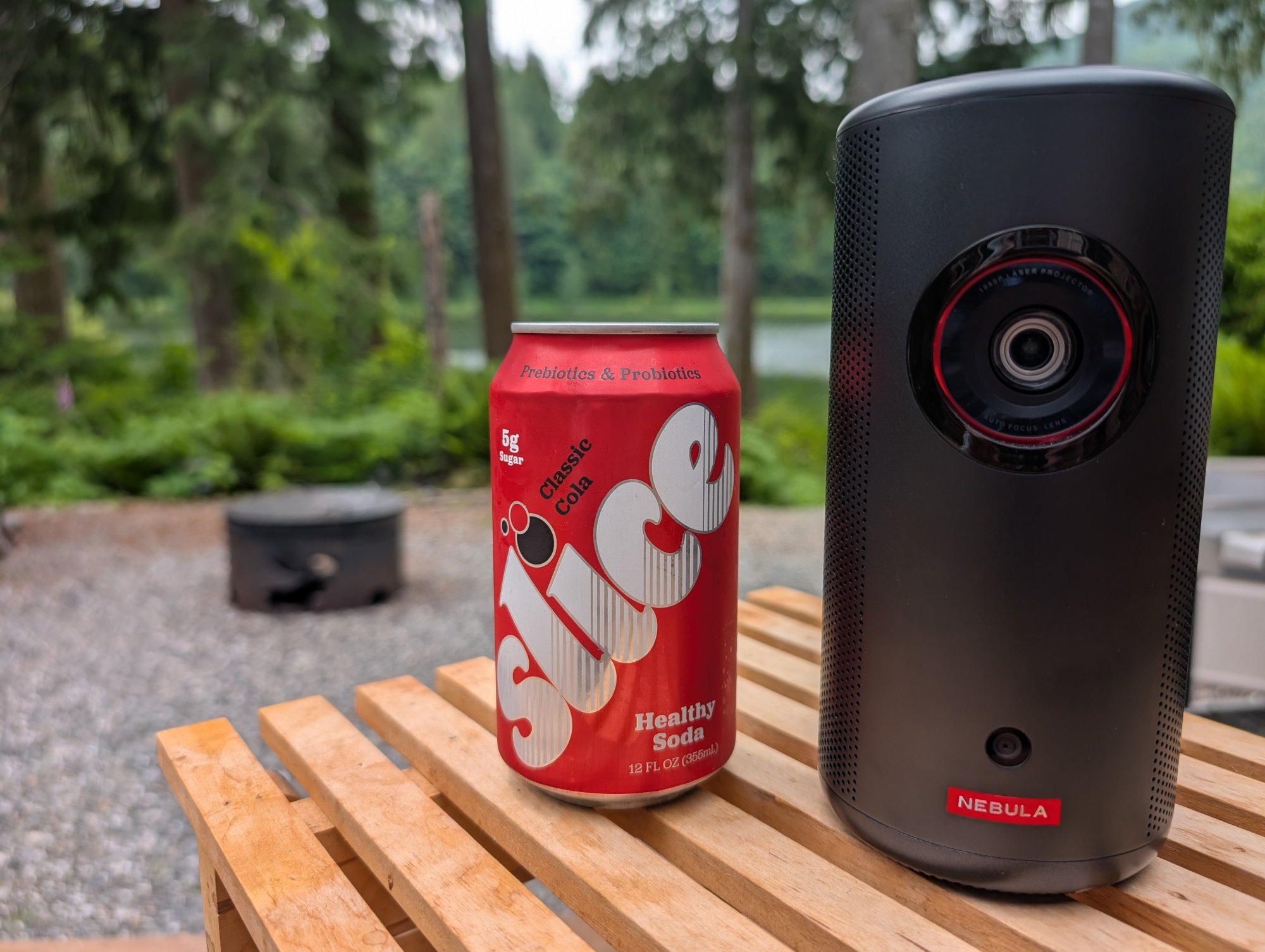 a can of slice soda next to the anker nebula capsule 3 laser projector