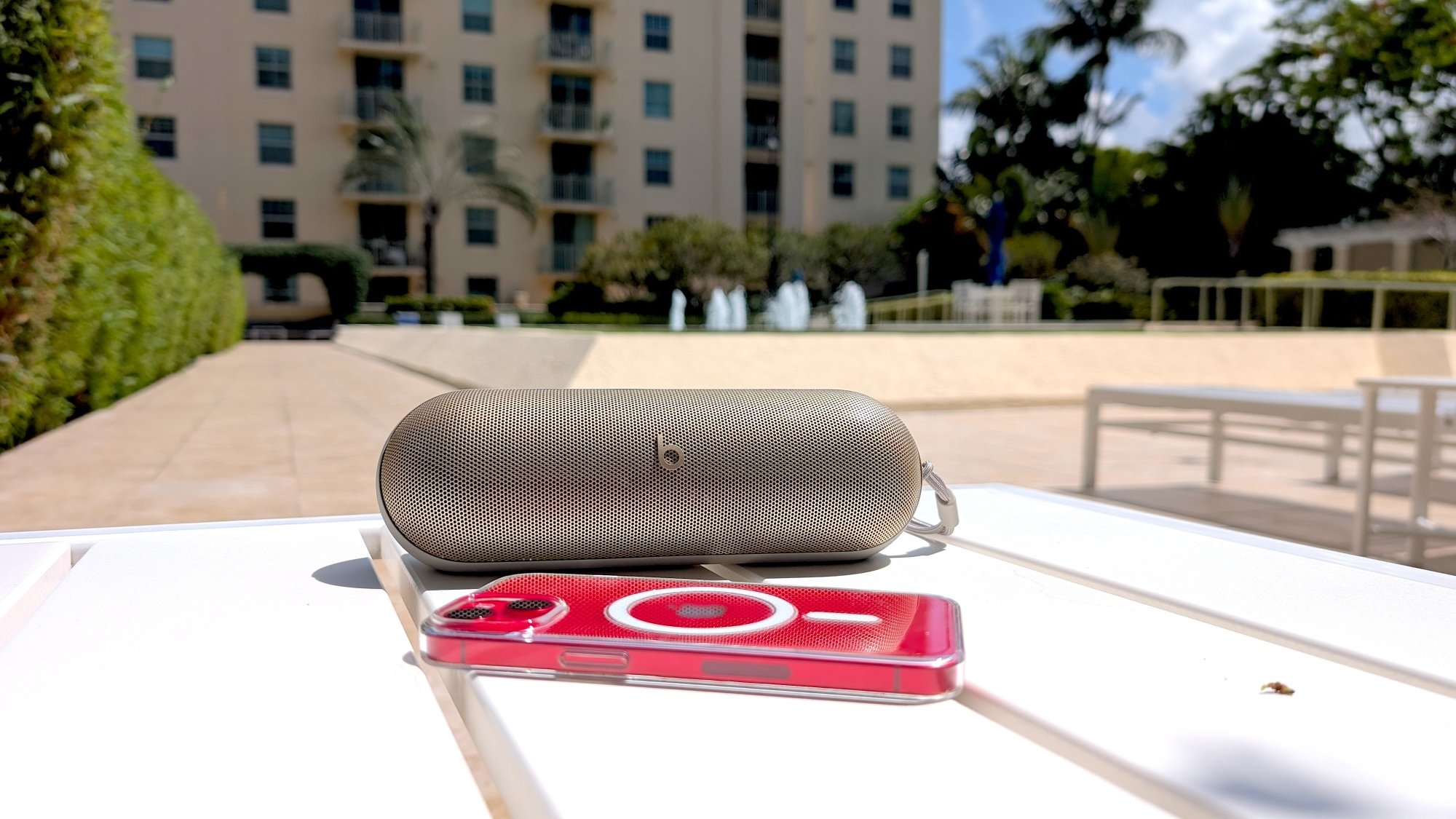 beats pill speaker with iphone on bench in courtyard