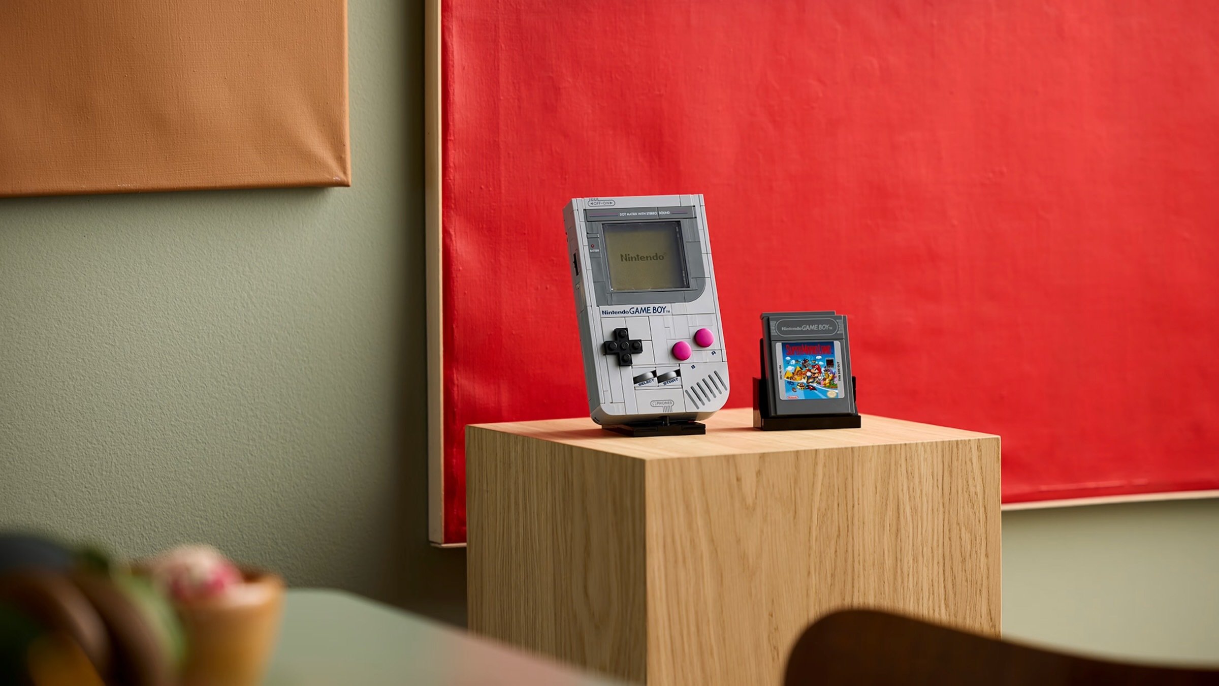 lego game boy building set with super mario cartridge on wooden plinth
